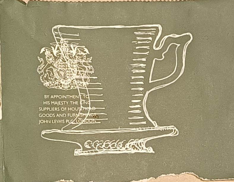 White pen drawing on green paper of cup & saucer