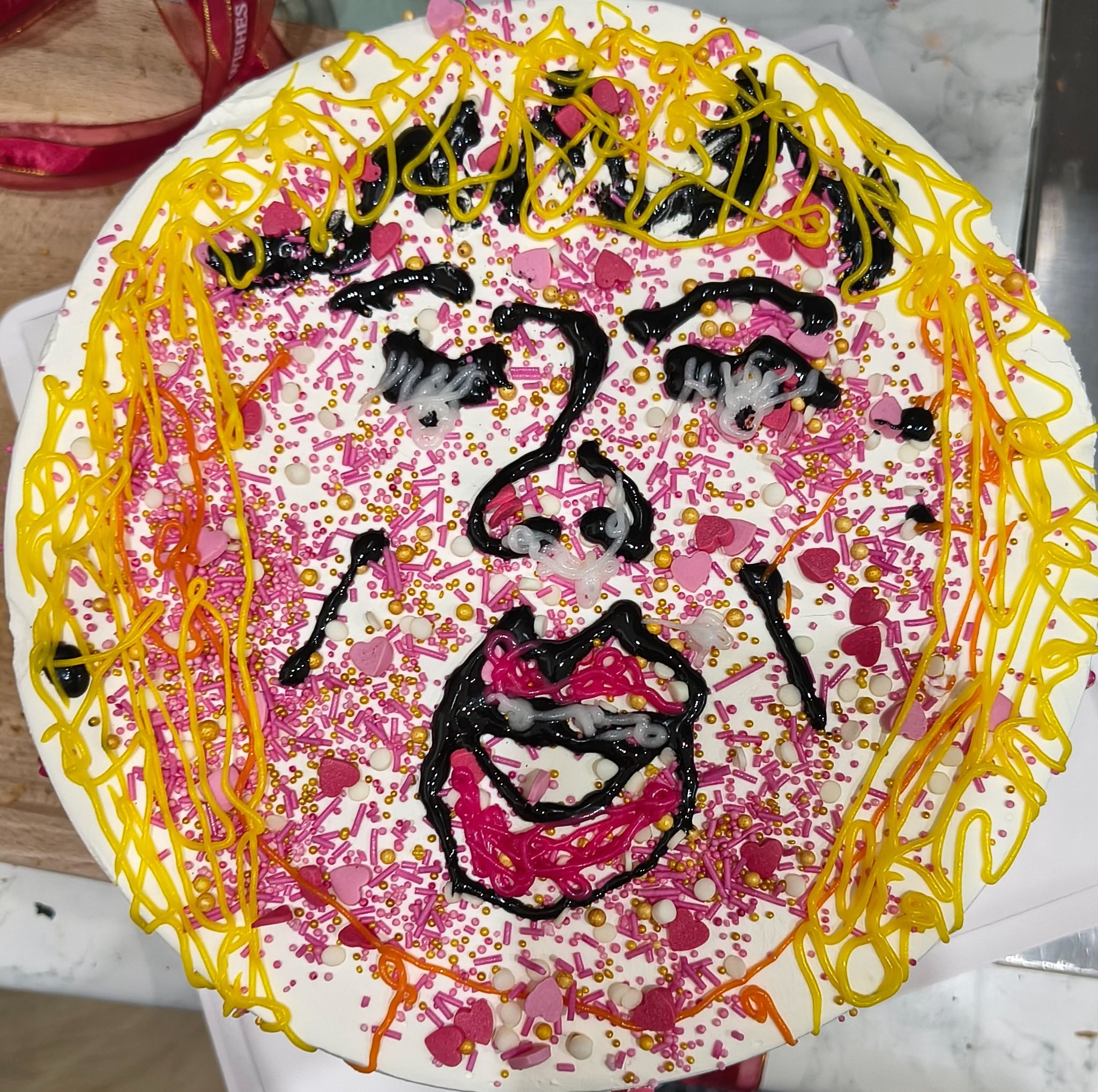 An image of a cake with a woman's face on it using icing