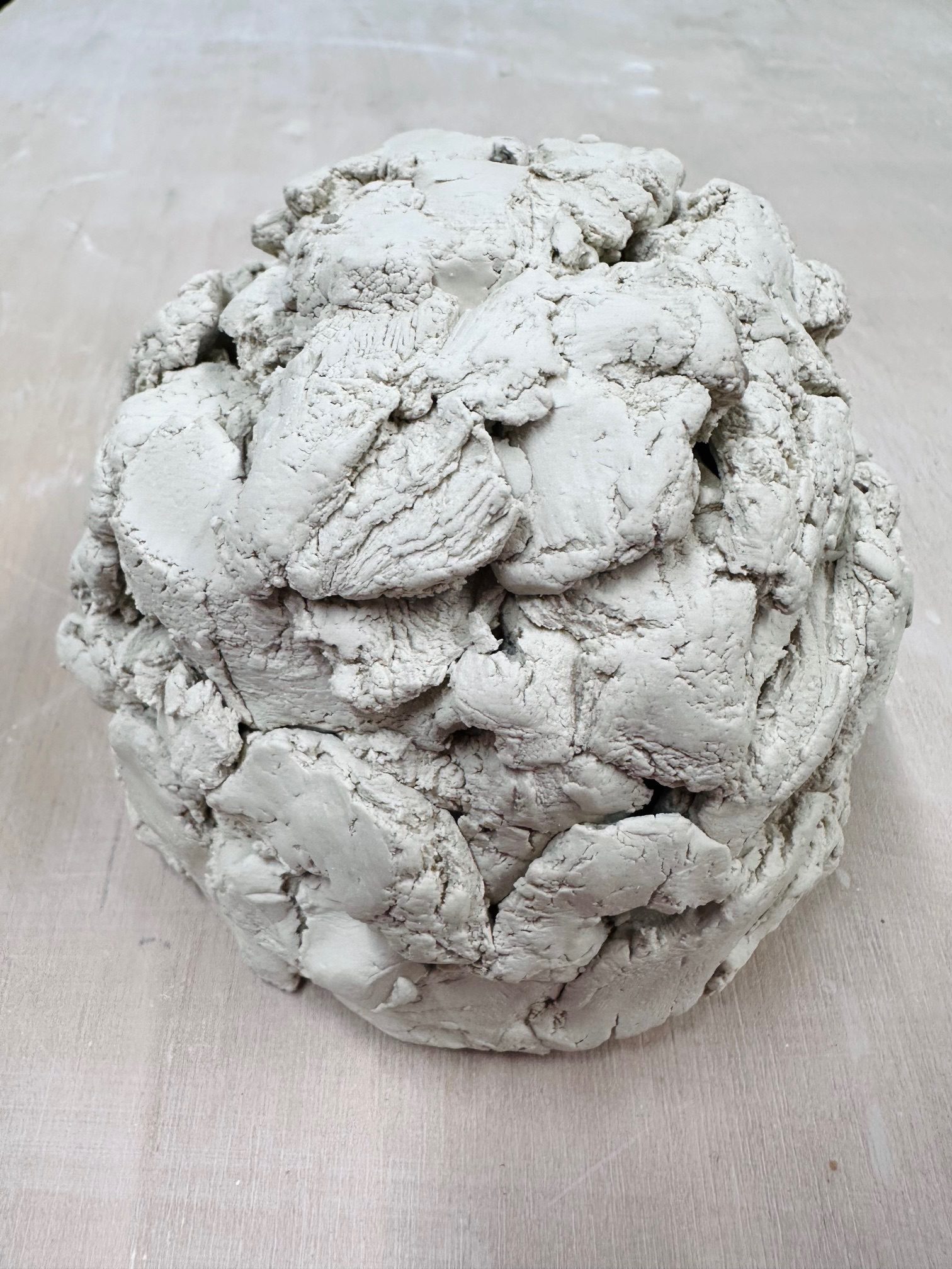 For recycling the porcelain, I tore a large mass into smaller pieces. The clay had formed in layers, and as I pulled it apart, it separated along these strata. Preserving the exposed cross-sections, I stacked the fragments into a dome-like form.