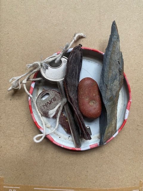 collection of ephemera in a jam jar lid