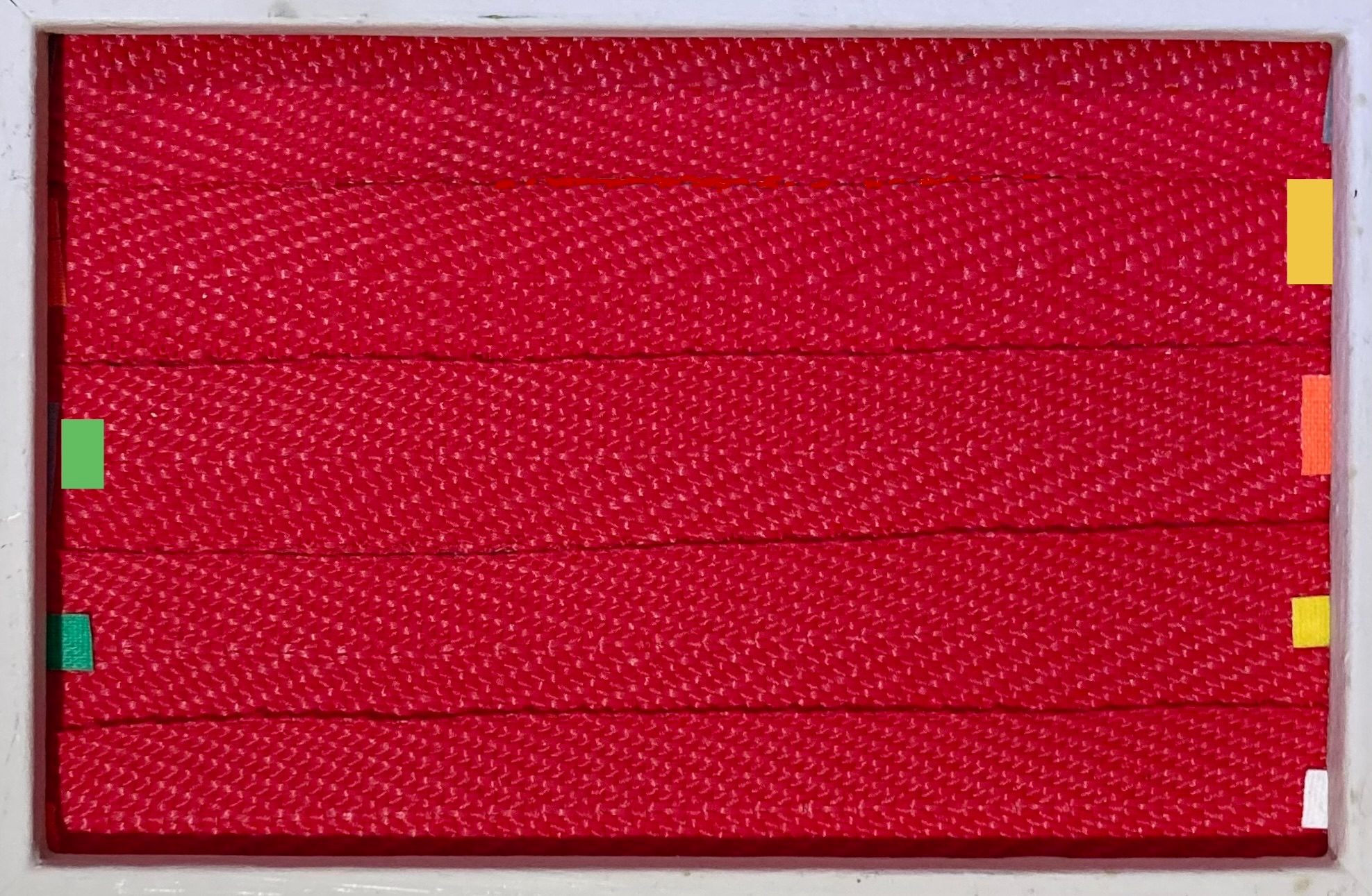 REd ribbons taped across an old frame using small offcuts of coloured tape either side