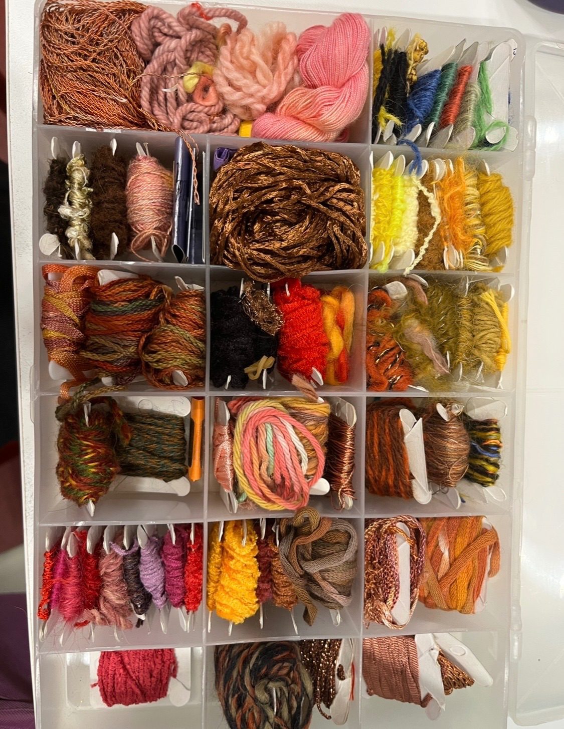A box of embroidery threads in different textures