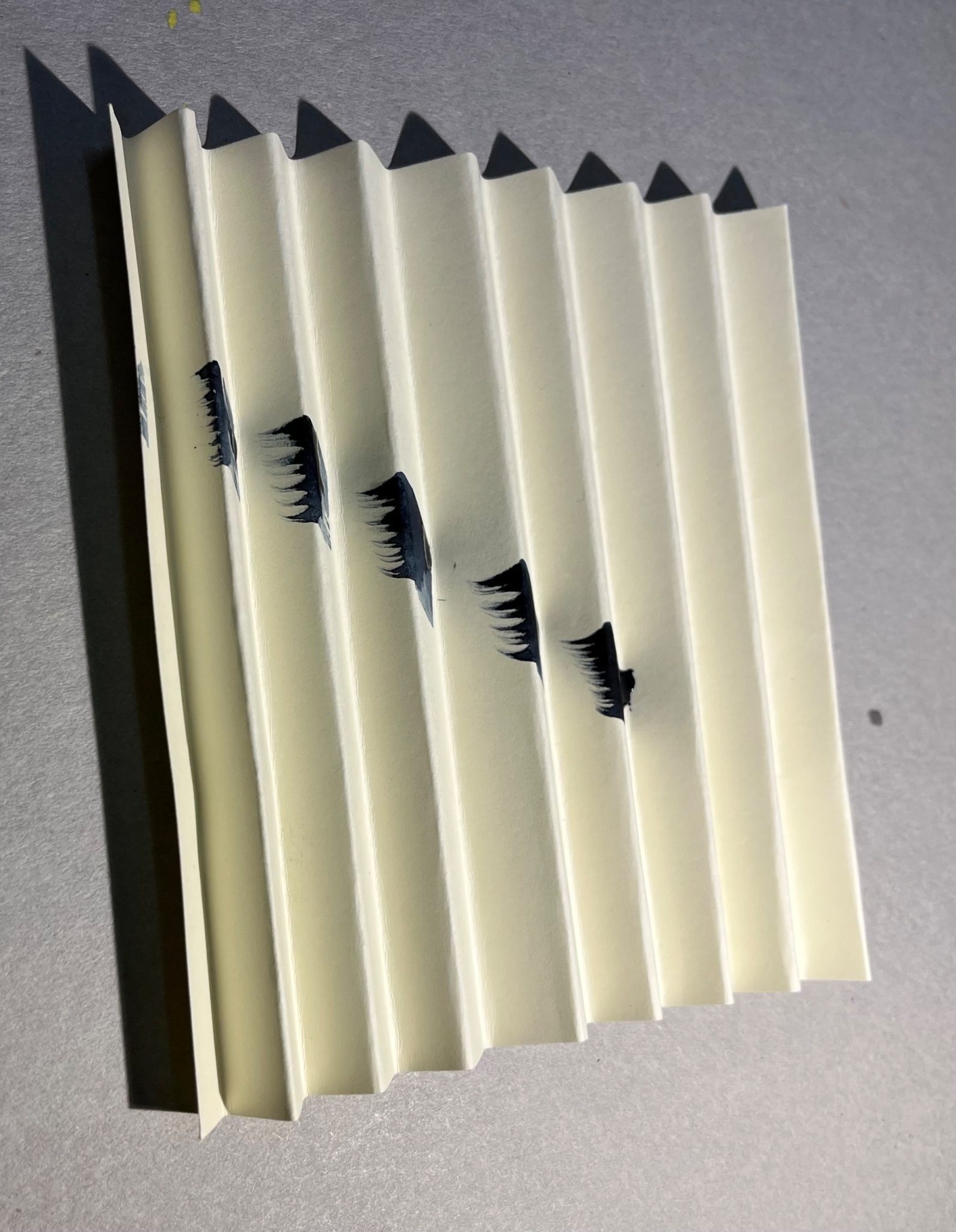 Folded paper with a dark brush stroke