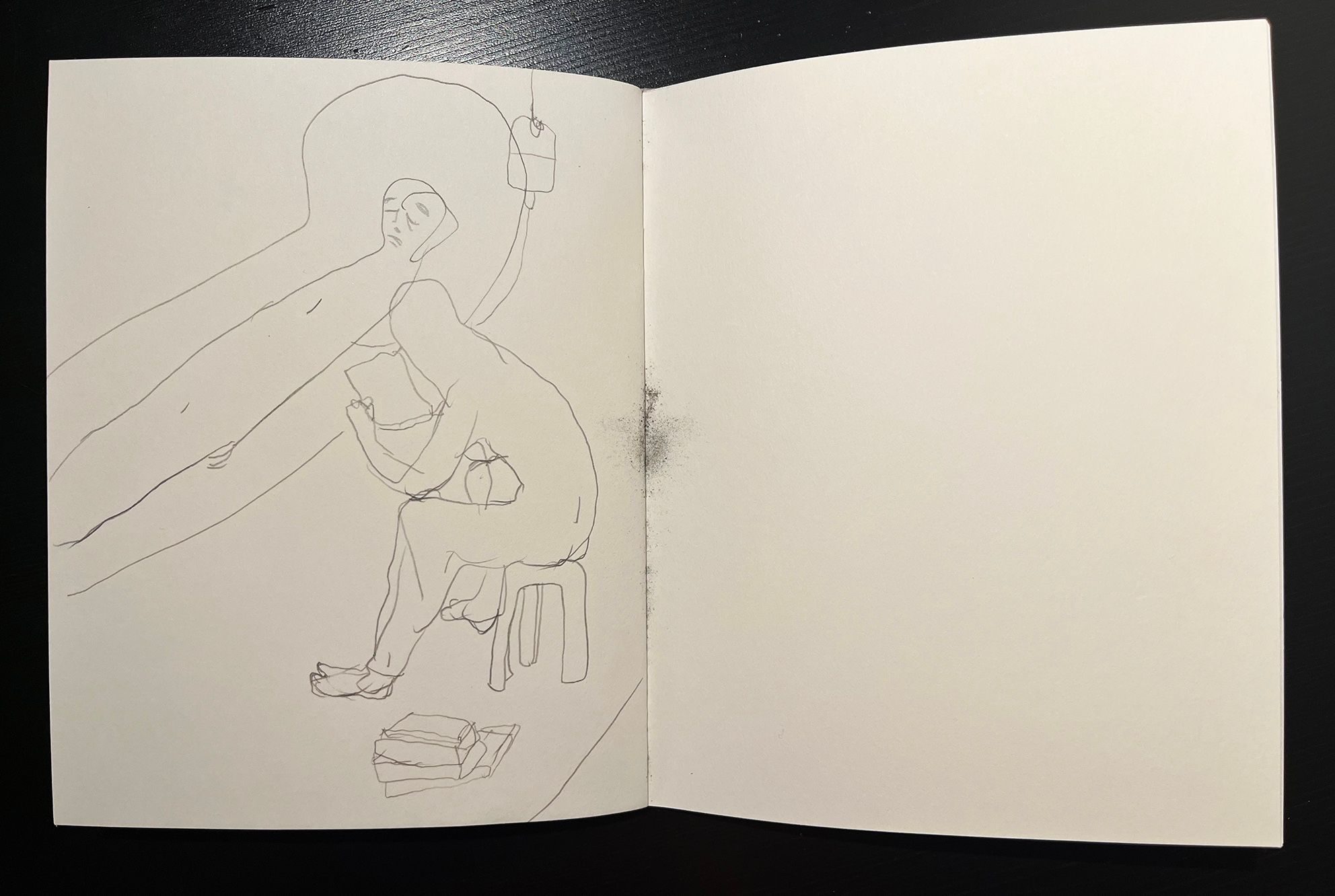 A notebook, open, with a pencil drawing inside.