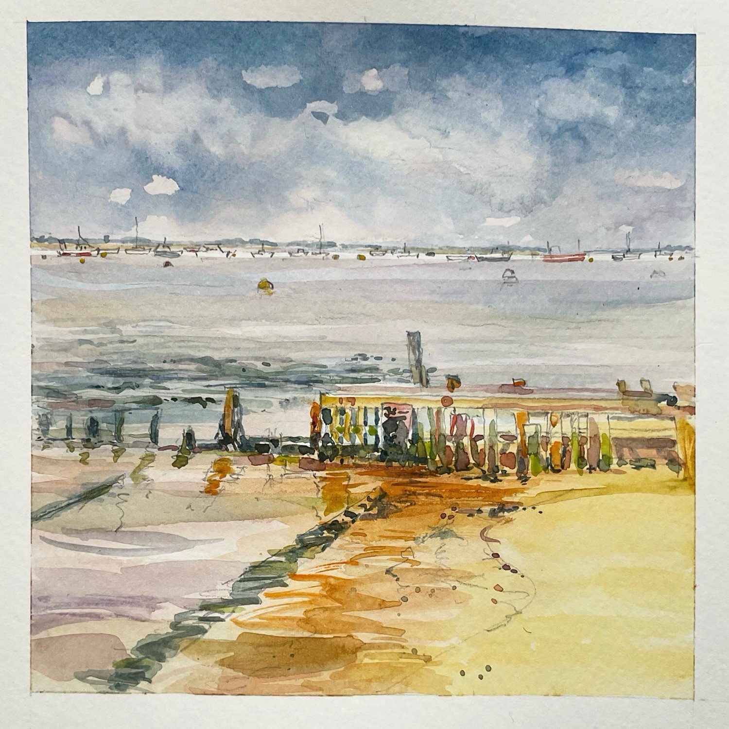 An ominous sky sits menacingly over a crowded anchorage on the East Coast UK. In the foreground is the rotting remains of a wooden jetty