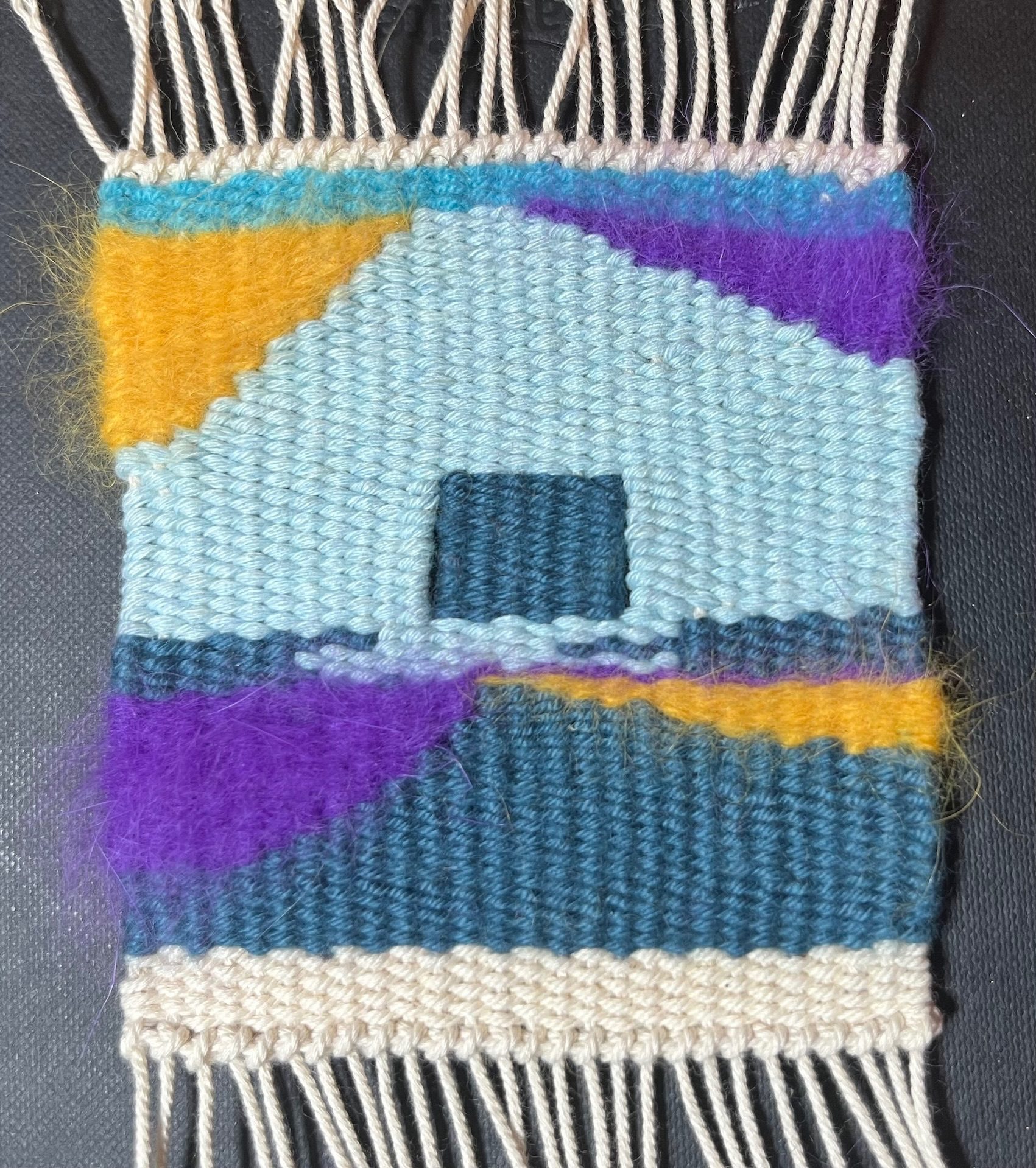 a small tapestry, using knitting and crochet would of different colours to make an abstract shape