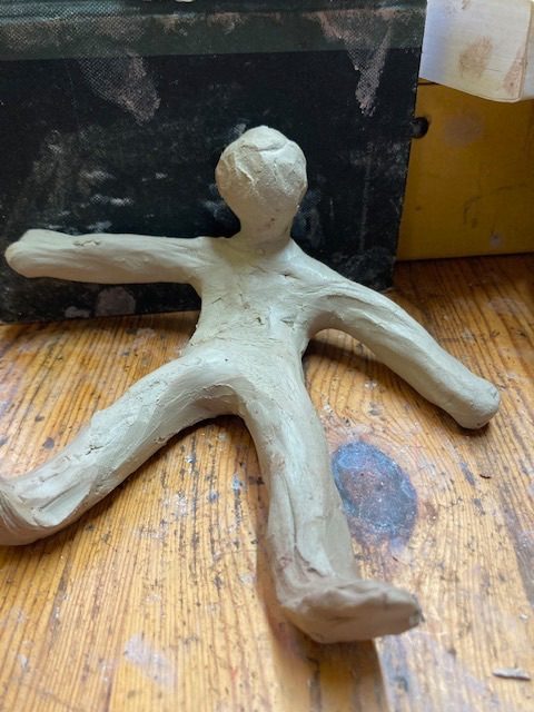 Clay person, starting to lift them self up from the ground