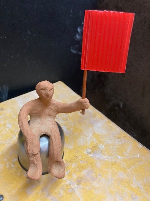 Clay person with a red flag