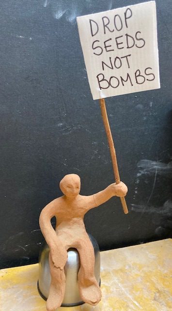 Clay person holding a protest banner