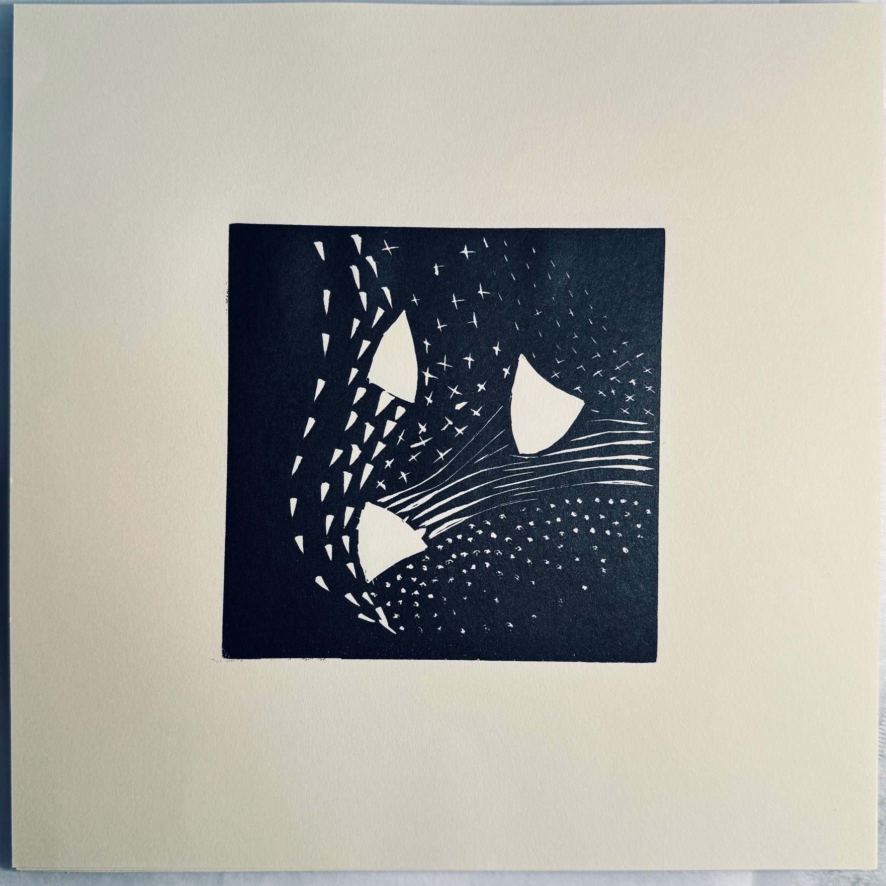 Square lino print of small abstract marks on soft white paper