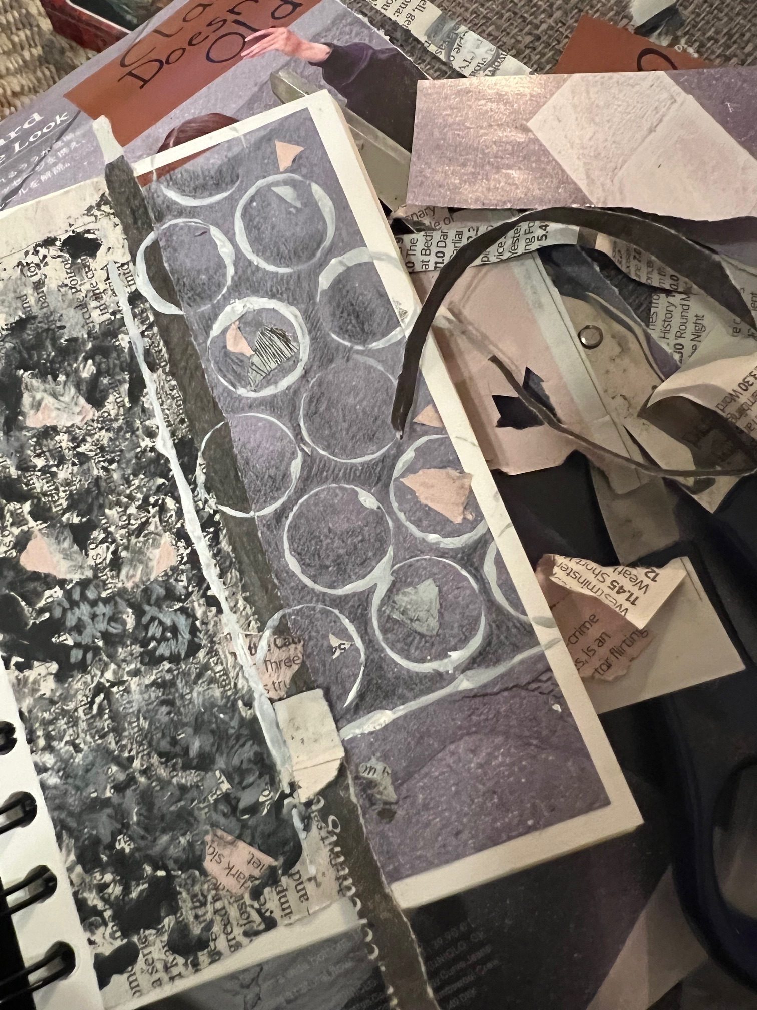 A sketch book with a collage and an overprint arranged next to a collection of sofa nesting debris