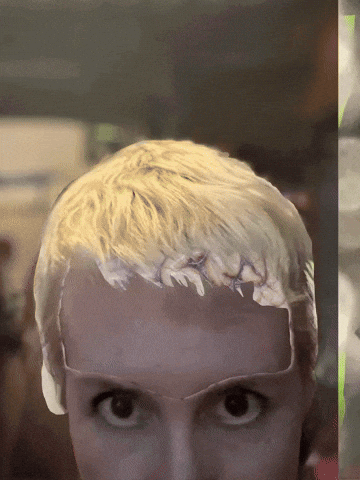 Animated gif showing a woman’s top part of her face with two eyes staring forward, she has short blond hair and her forehead oscillates between a brain and skin. Lime green abstract shapes flas in and out on the background