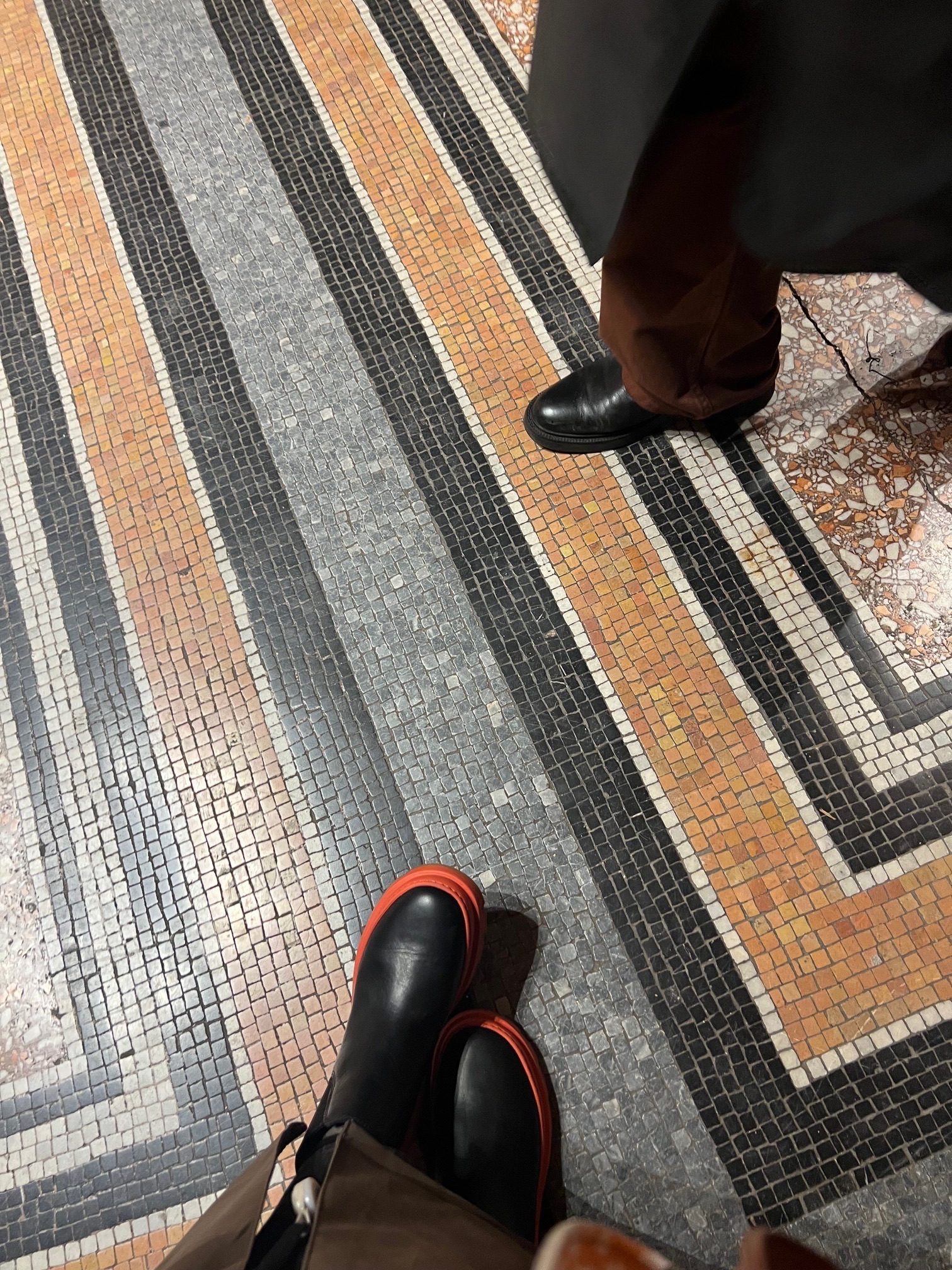 Photo of two sets of feet on mosaic floor