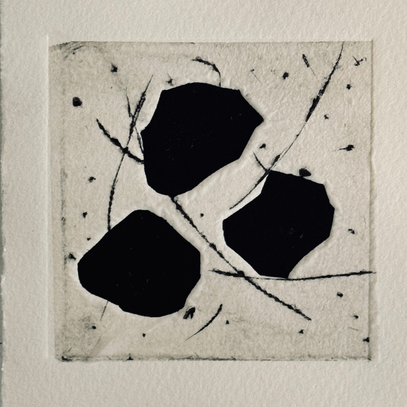 Relief print with chine collé. Three irregular black forms in the centre of the print, on a background of file lines and marks.