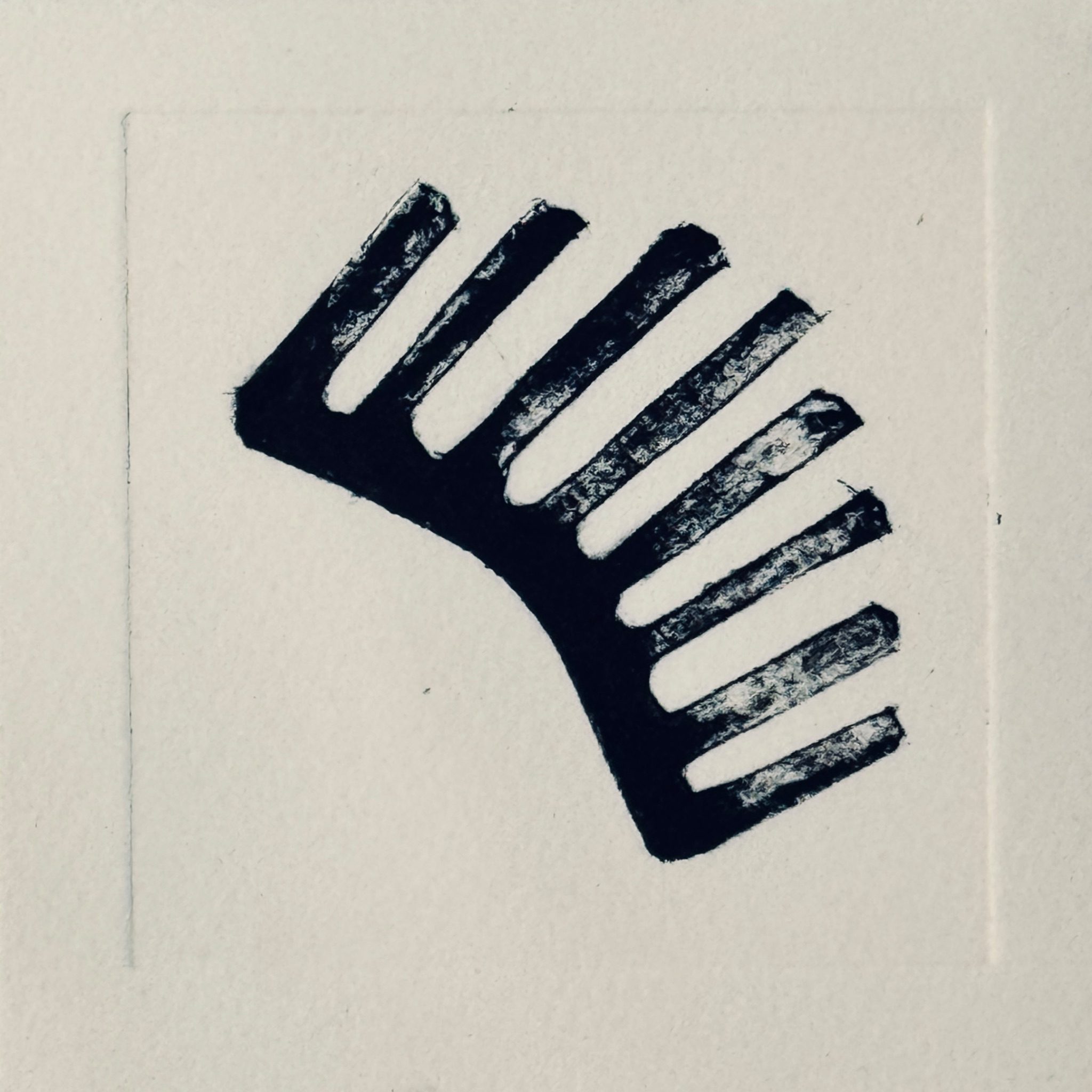 Reflect print of a black form, reminiscent of a convex wide toothed comb.