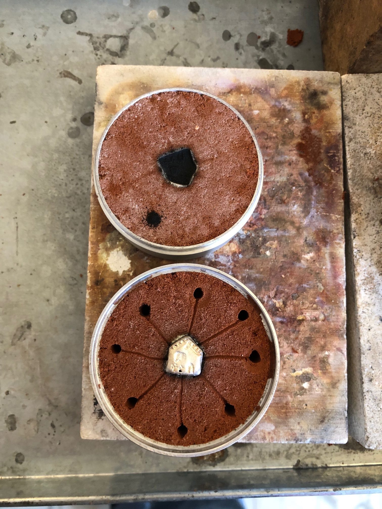 photograph of the immediate result of sand casting a tiny silver house