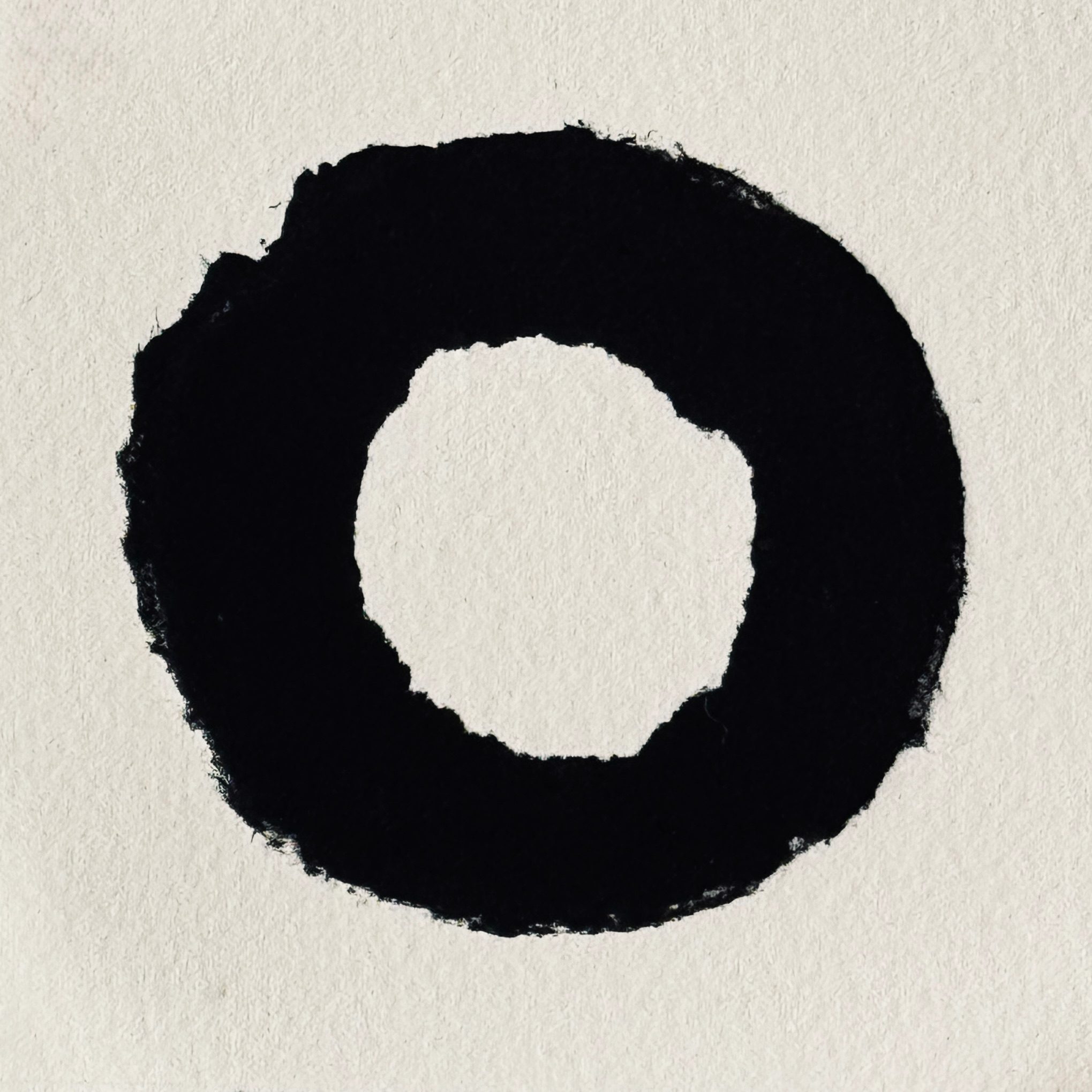 Relief print of a circle with torn edges printed in black