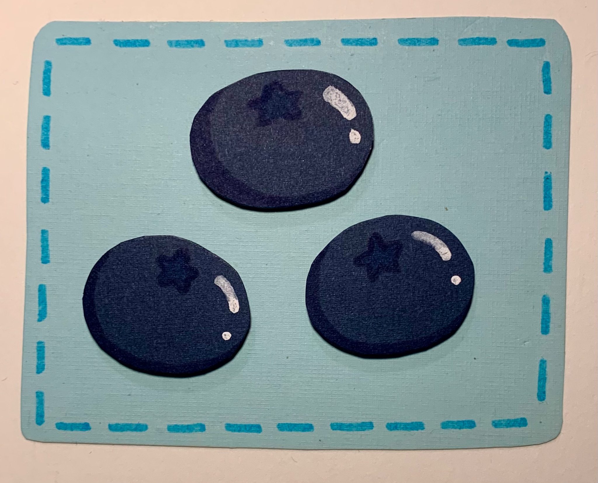 An illustration of three blueberries using card