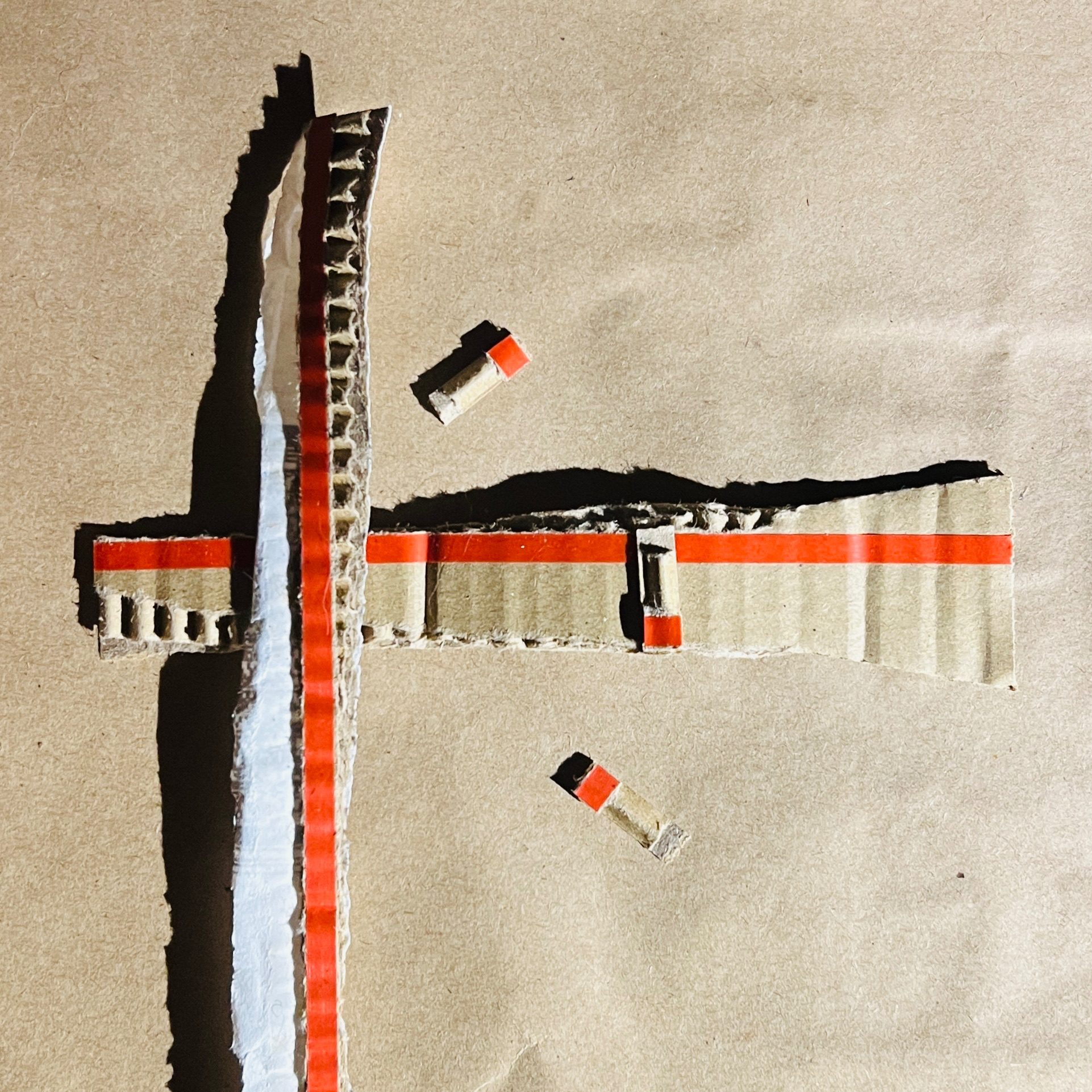 Collage of pieces of red rip-strip from cardboard envelopes.