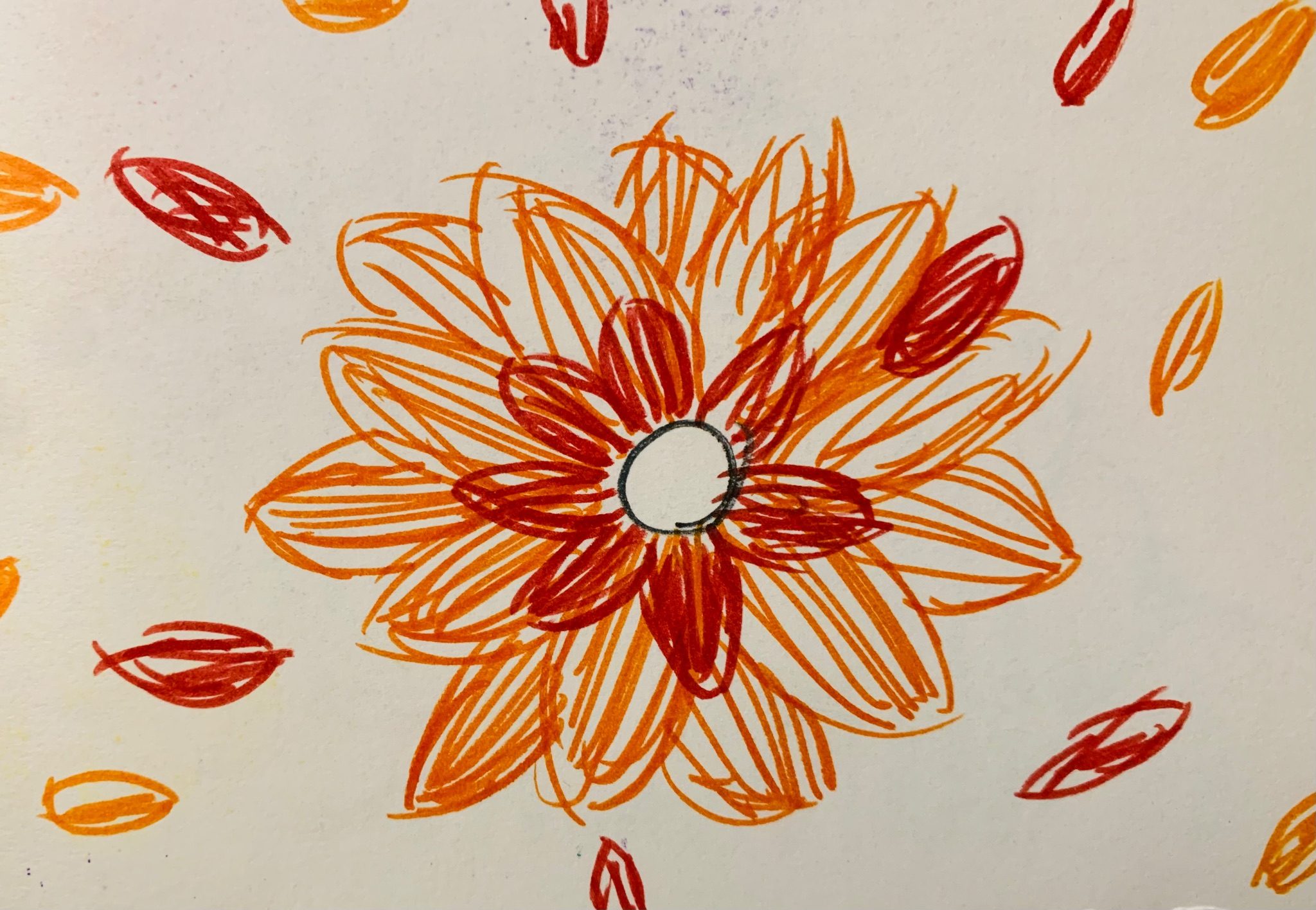 A sketch done in felt tip pen with a white circle in the middle and red and orange petal-like shapes surrounding it.