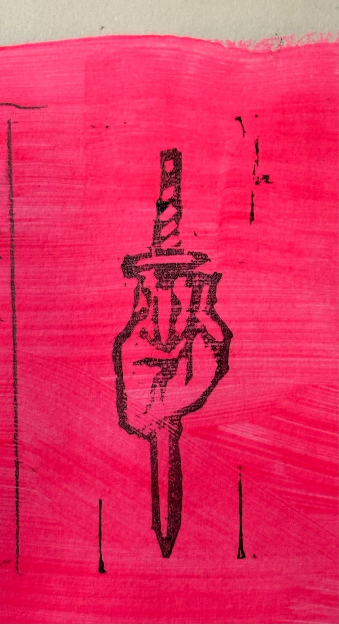 A small rubber sized lino print of a heart with a sword through it. Printed with black ink on a neon pink background