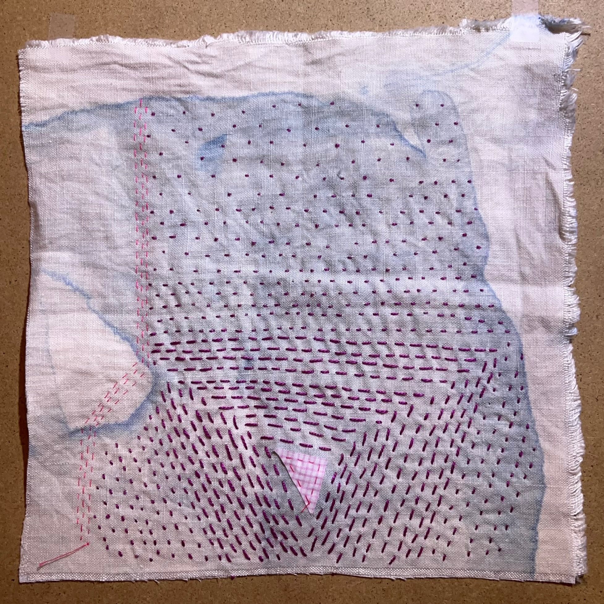 A 6 inch square of white linen with short frayed edges all round. Very pale blue dye has washed over most of the fabric, leaving just the top and right edges uncoloured. A tiny pink triangular scrap of fabric is stitched at the bottom centre. Deep pink straight stitches are worked around this scrap, creating concentric triangles, spreading out from the scrap, the stitches shrinking as they get further out, eventually becoming tiny dots.