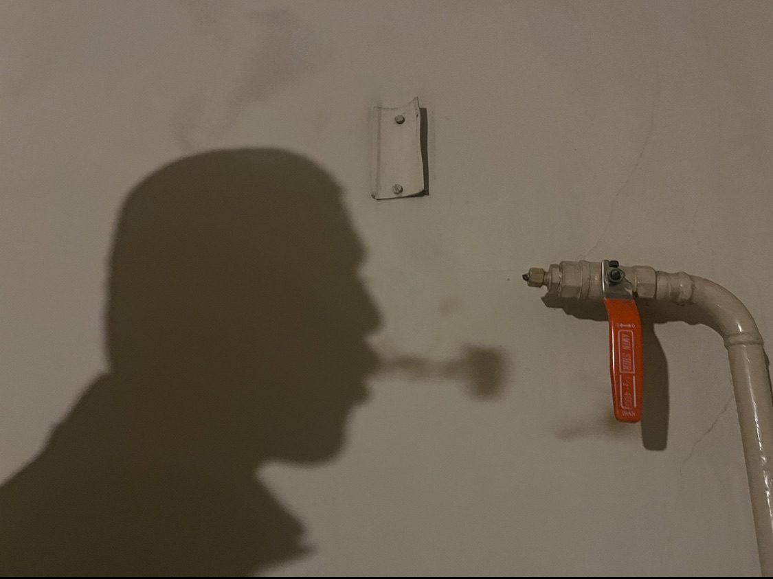 Picture of a shadow of a man blowing smoke