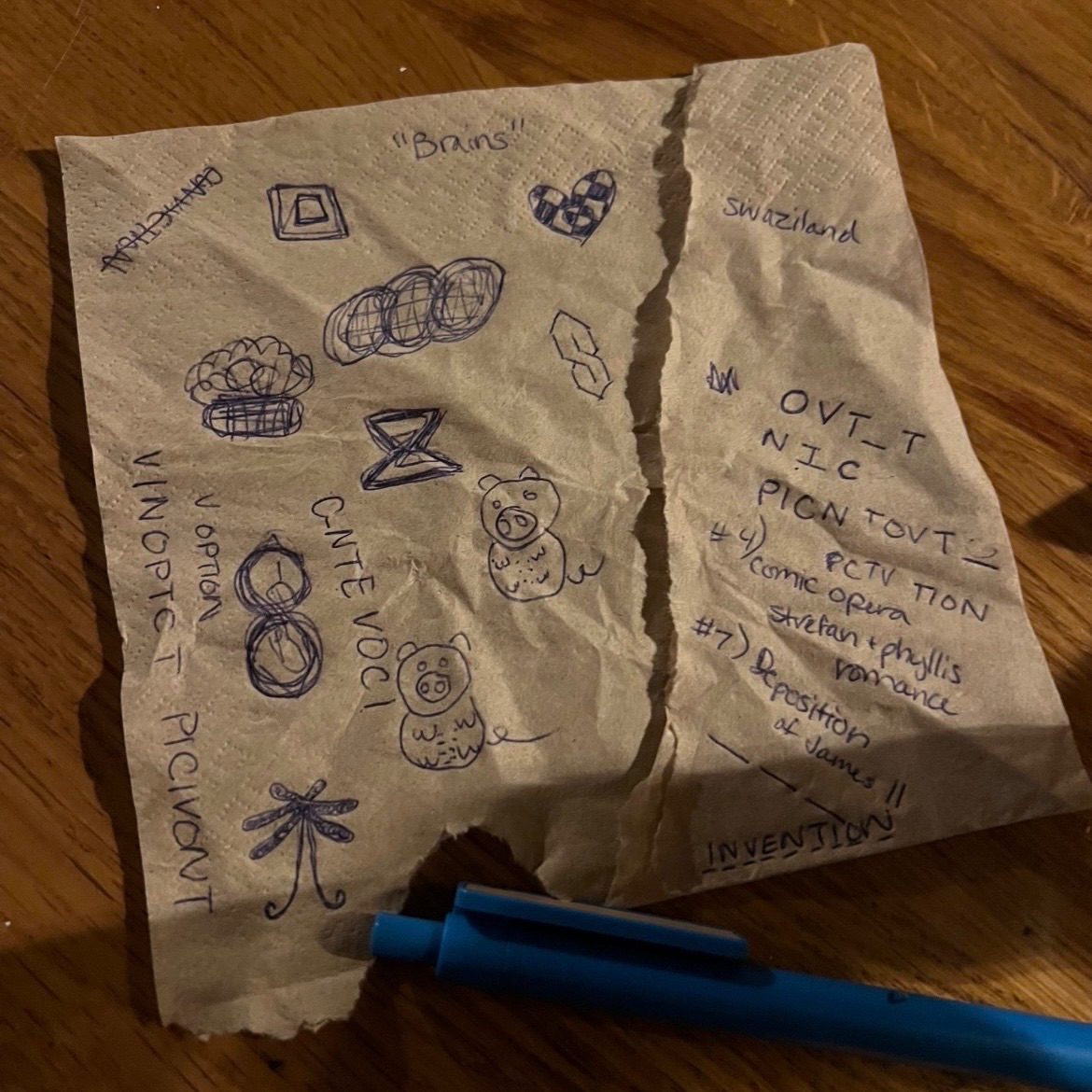 Scribbles of words and doodles on a ripped napkin