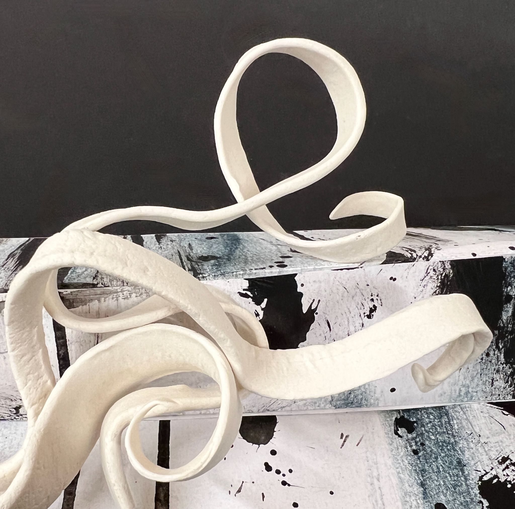 clay spirals and cut paper on black paper