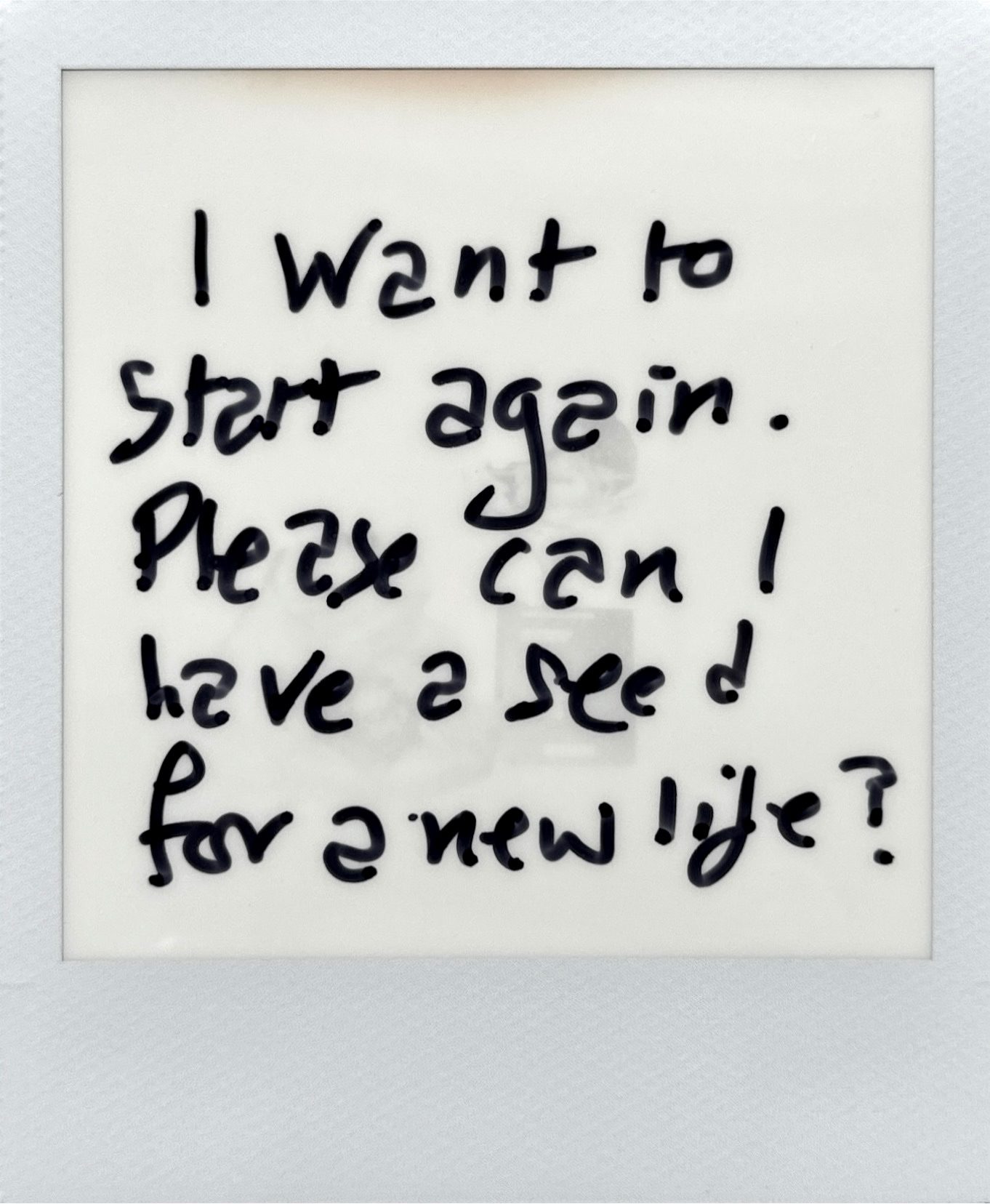 A black and white muted Polaroid photo with text written on the top of it.