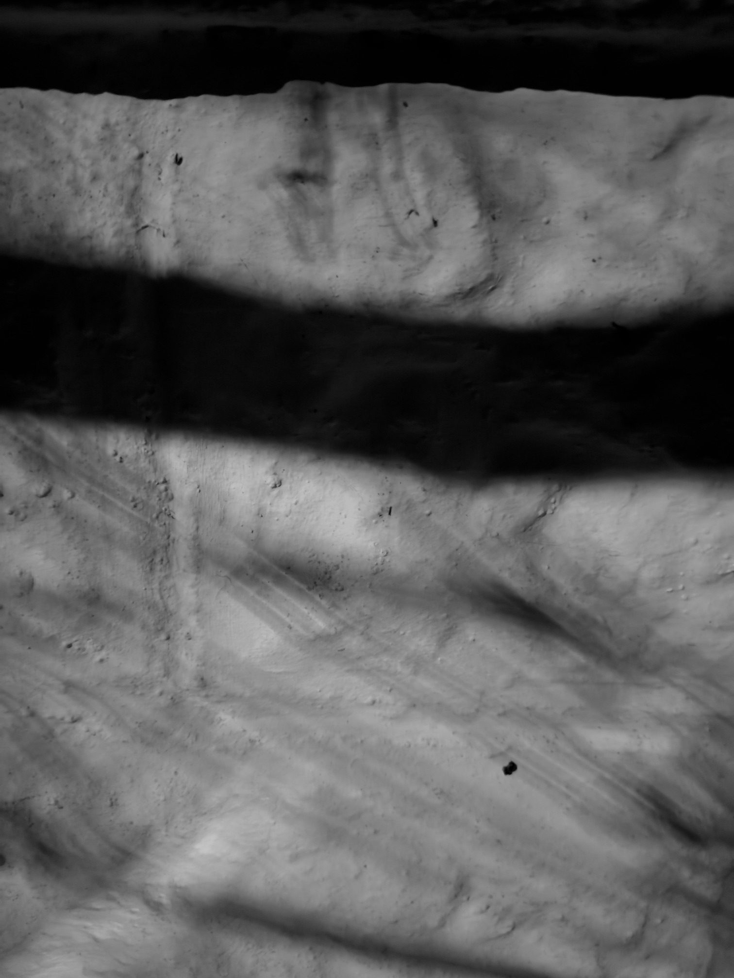 A black and white abstract photograph of wall and shadow all the things we cannot see.