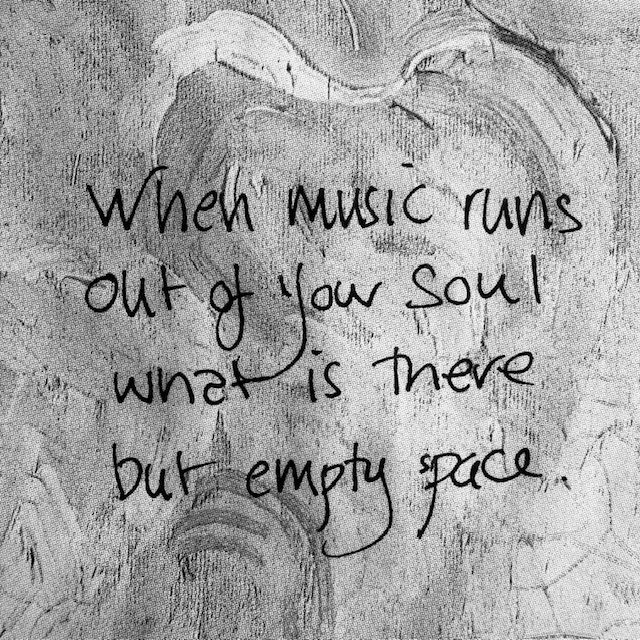 A black and white photo with text hand written on an old patterned paper bag.