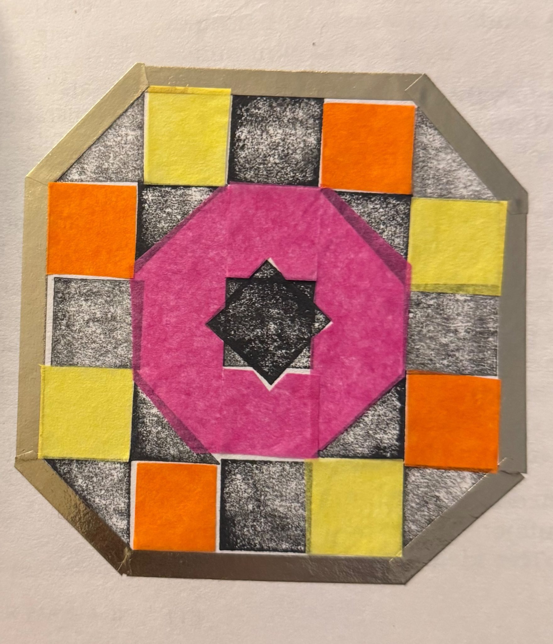 Black and white stamped shapes, with coloured pieces of tissue paper on top, surrounded by a gold tape frame.