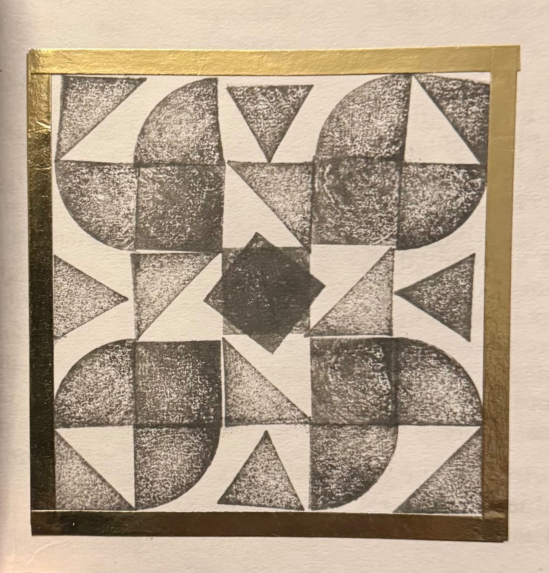 Black and white pattern made with squares and triangles within a golden tape square.