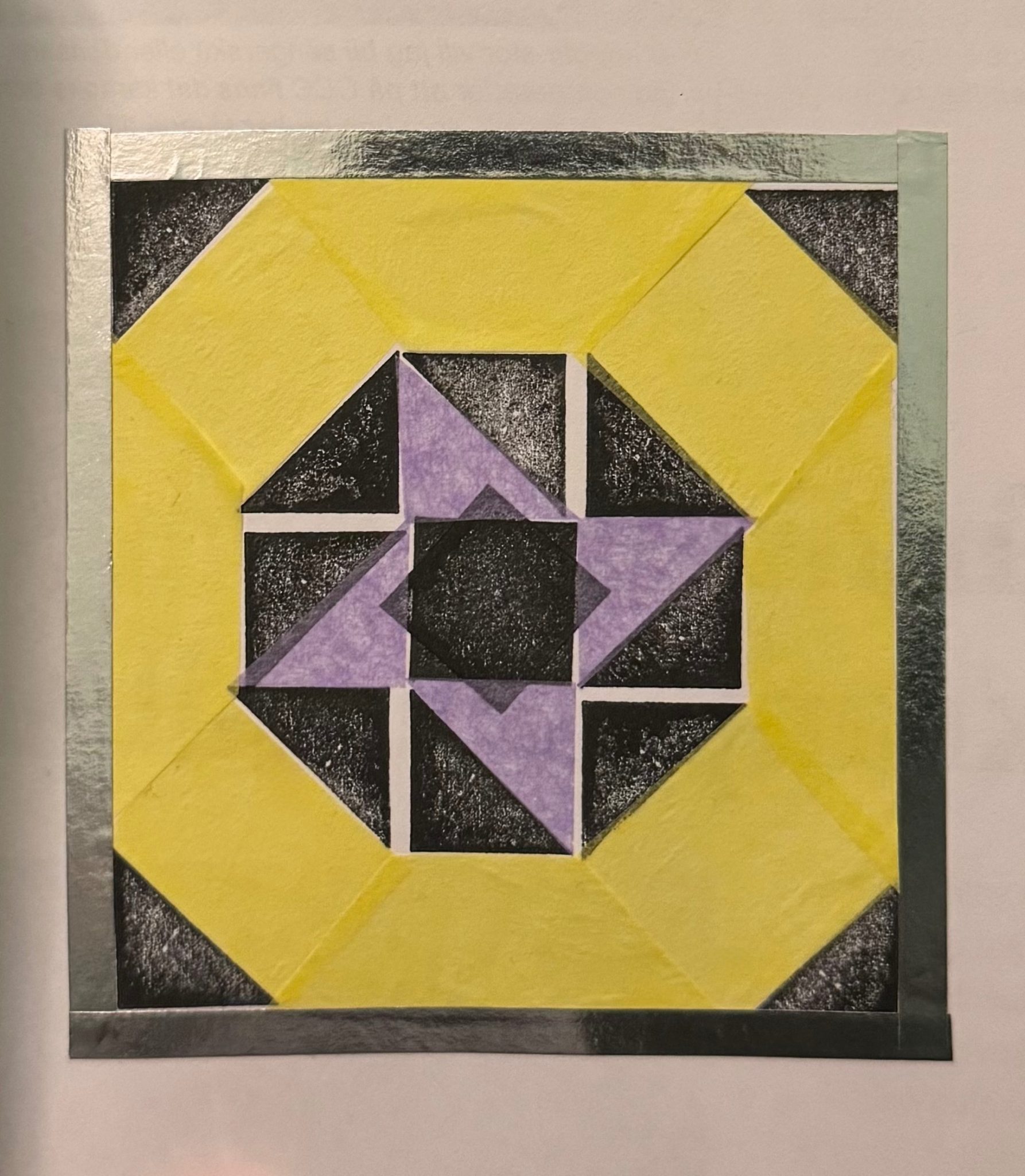 Black and white shapes form a pattern in a square with coloured pieces of tissue paper, and a tape border.