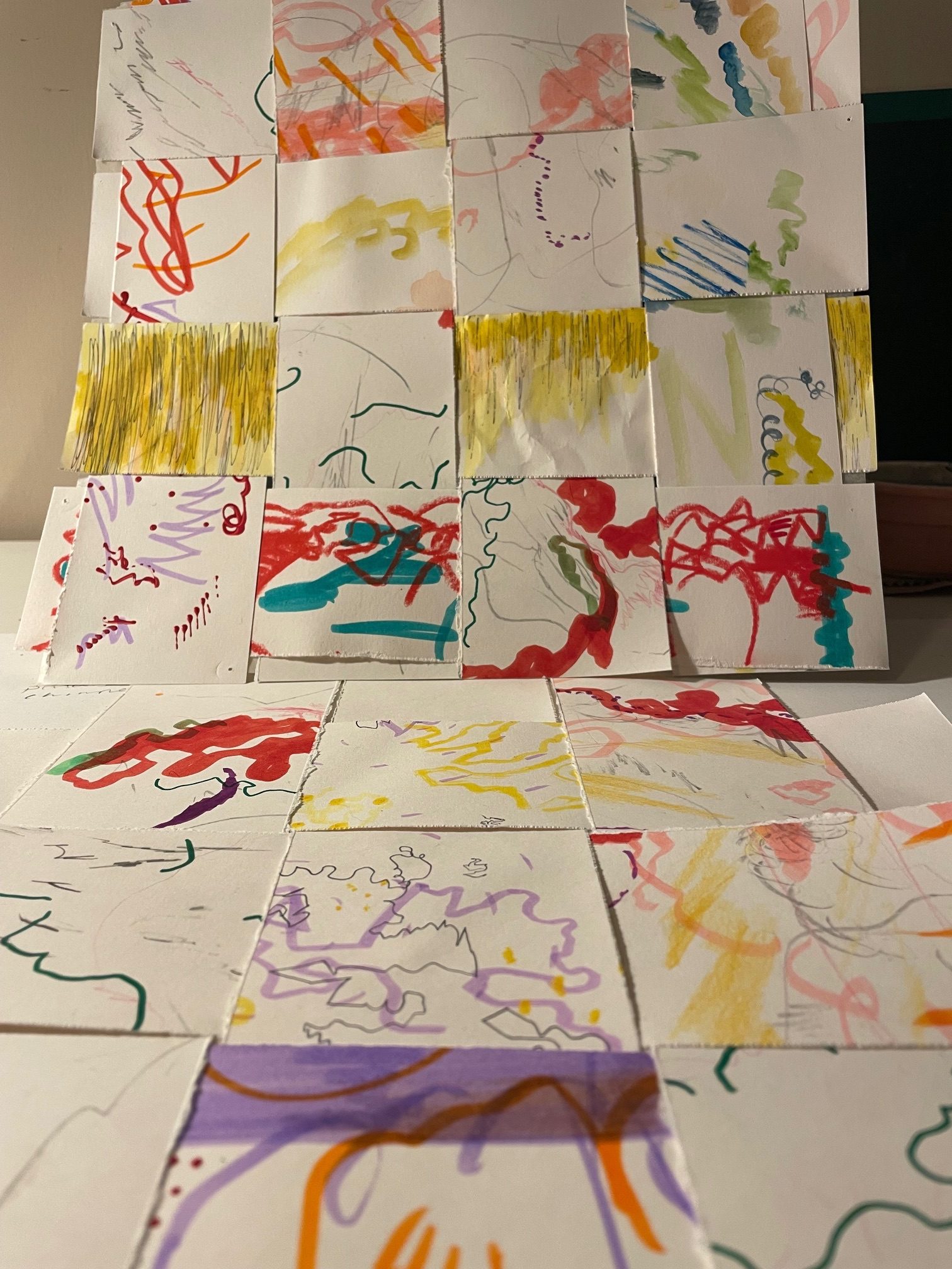 Paper strips with coloured line drawings on woven together to make sort of a mat. The drawings represent sounds that participants in a drawing sounds workshop made