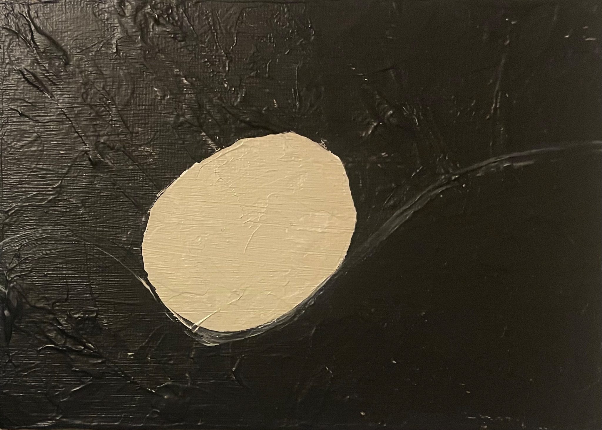Black painted panel with a creamy oval in the middle