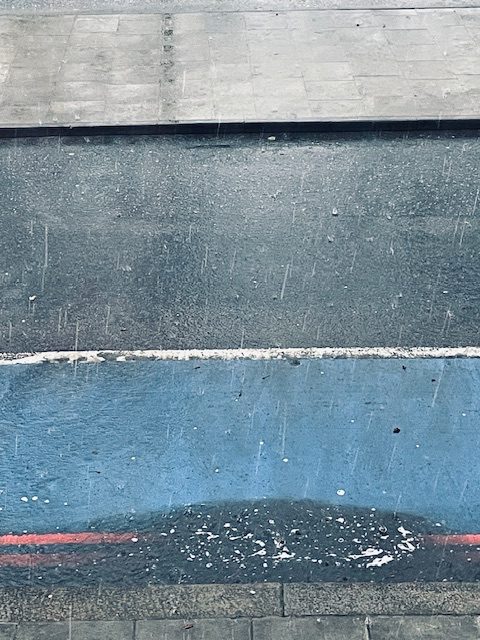Photo of a rainy London street. Composition has lots of horizontal lines