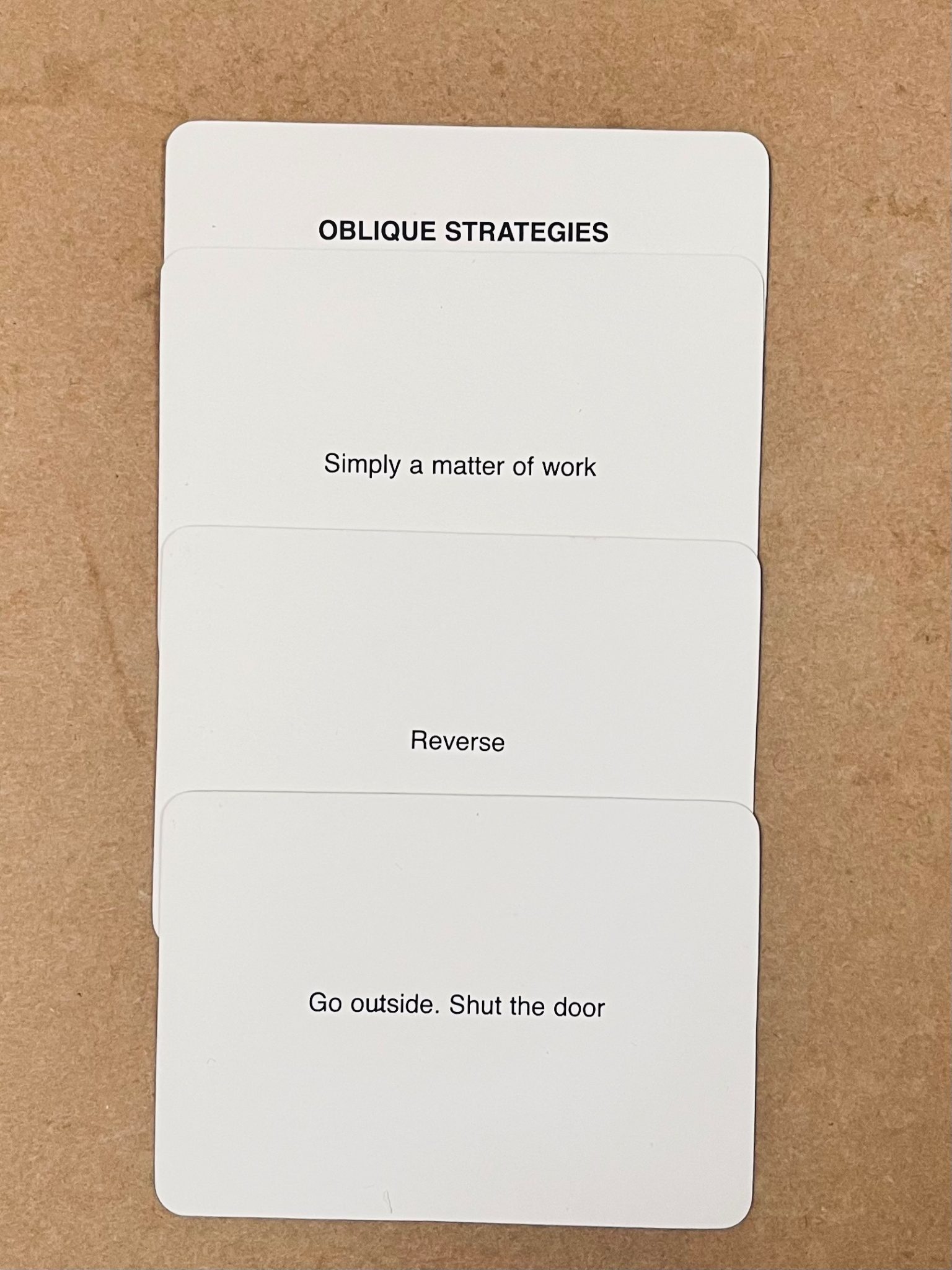 4 oblique strategies cards creat the following poem. Oblique Strategies / Simply a matter of work / Reverse / Go outside. Shut the door