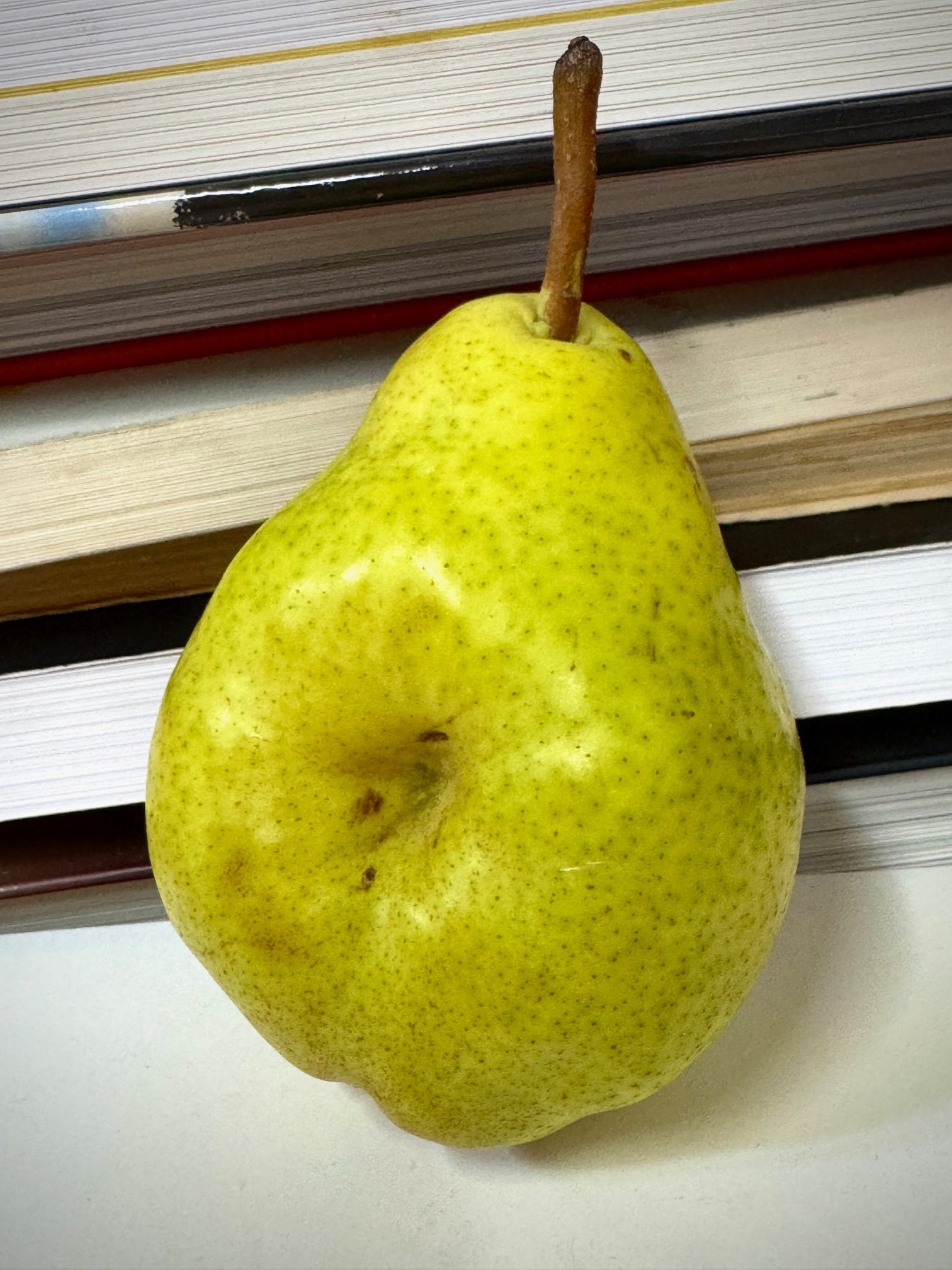 A photo of a pear and books