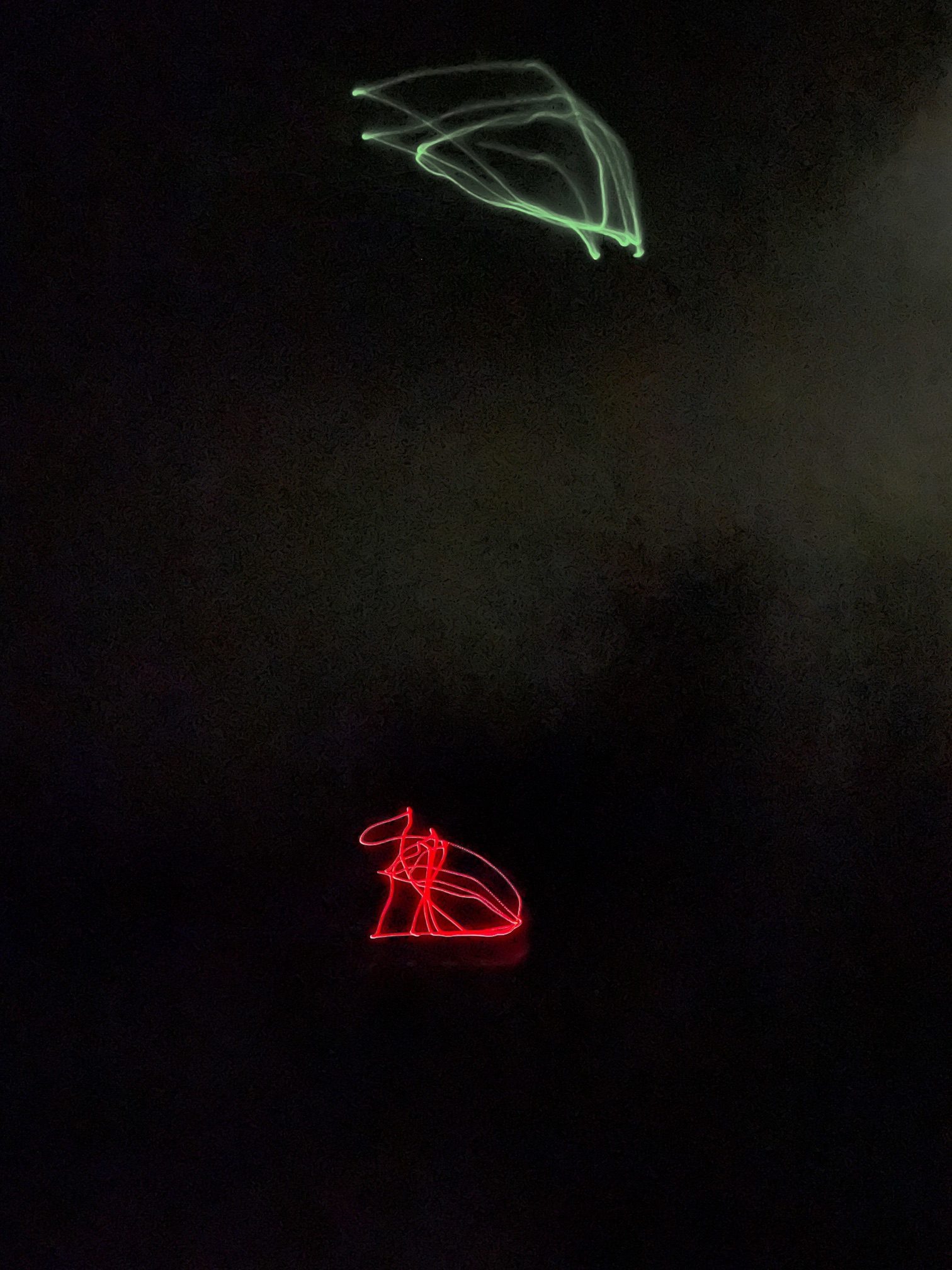 Photograph in the gloom of a room with traces of red and green lights
