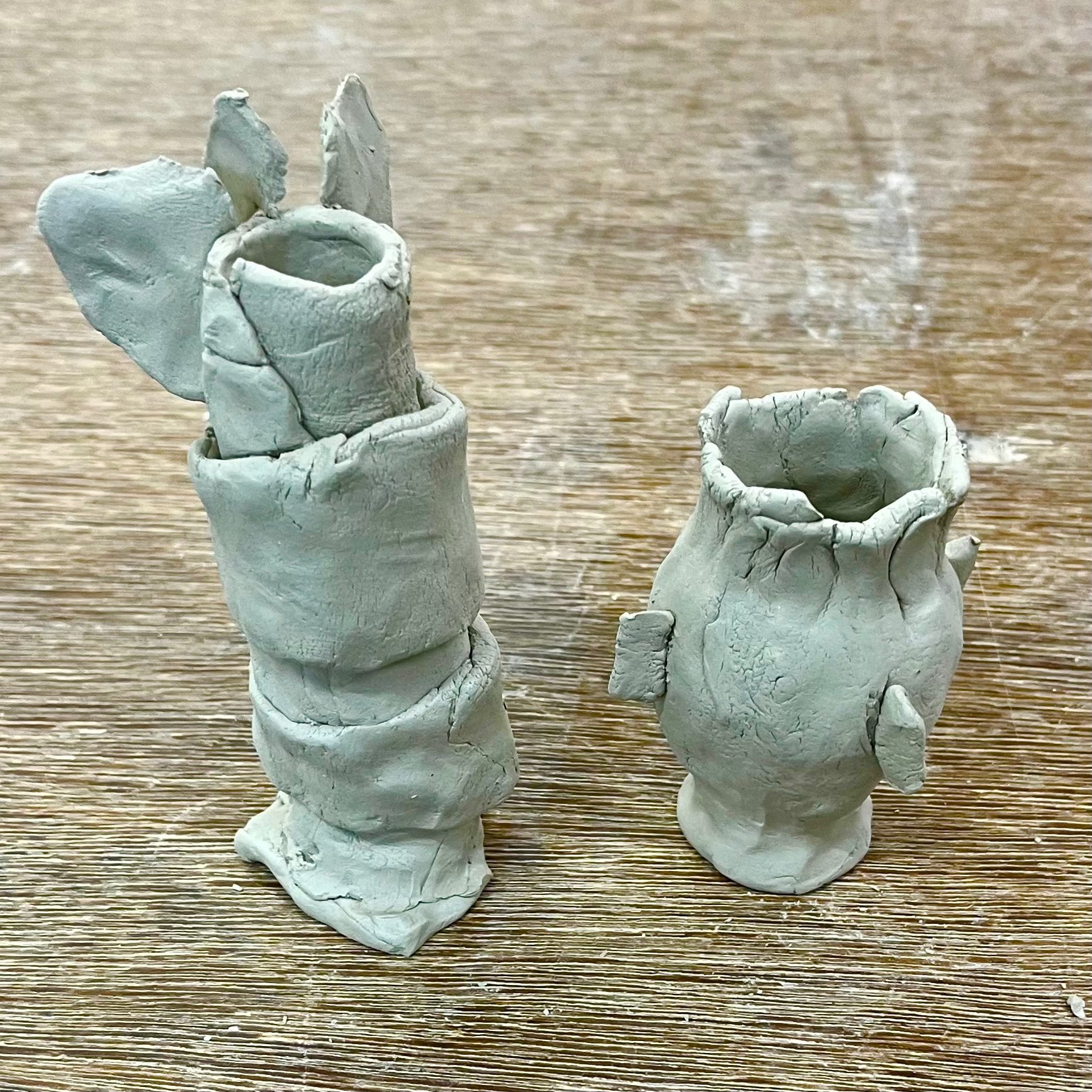 2 sculpted pinched clay vessels