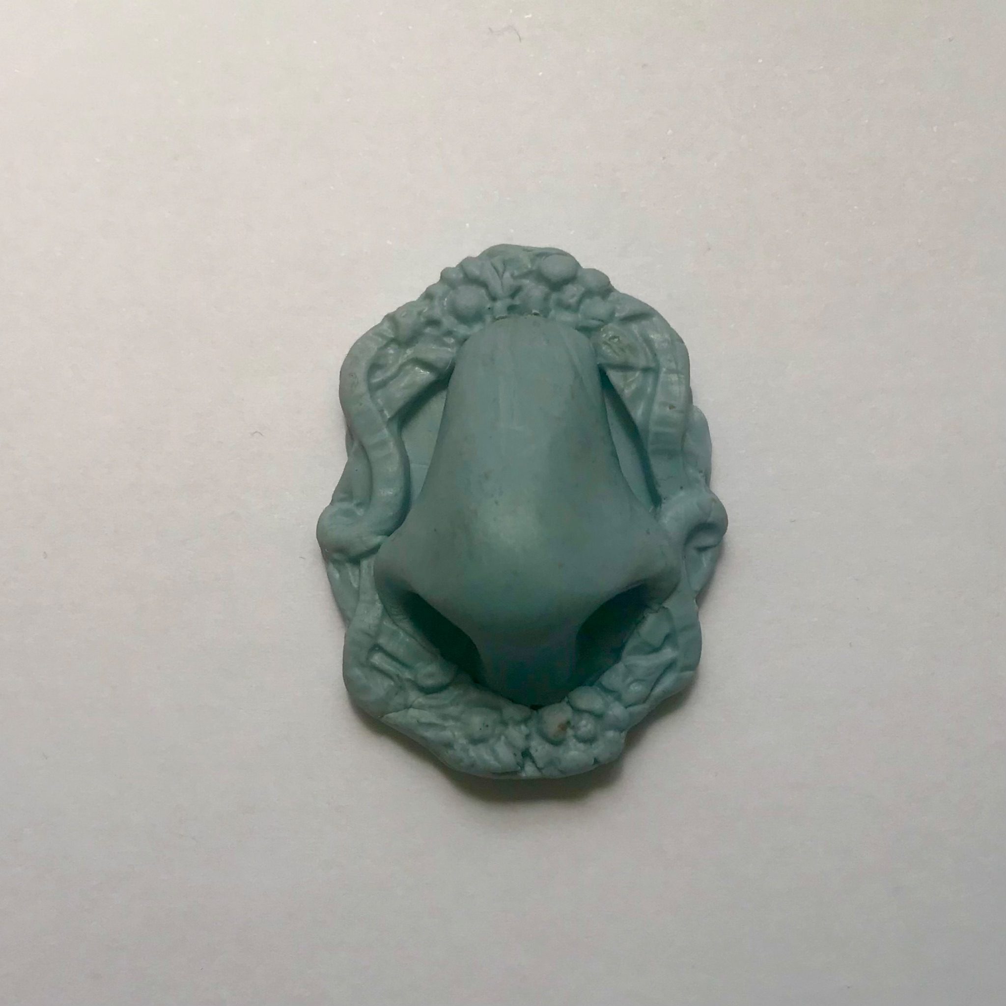 A Blu Tack sculpture of a small blue nose in a small blue frame