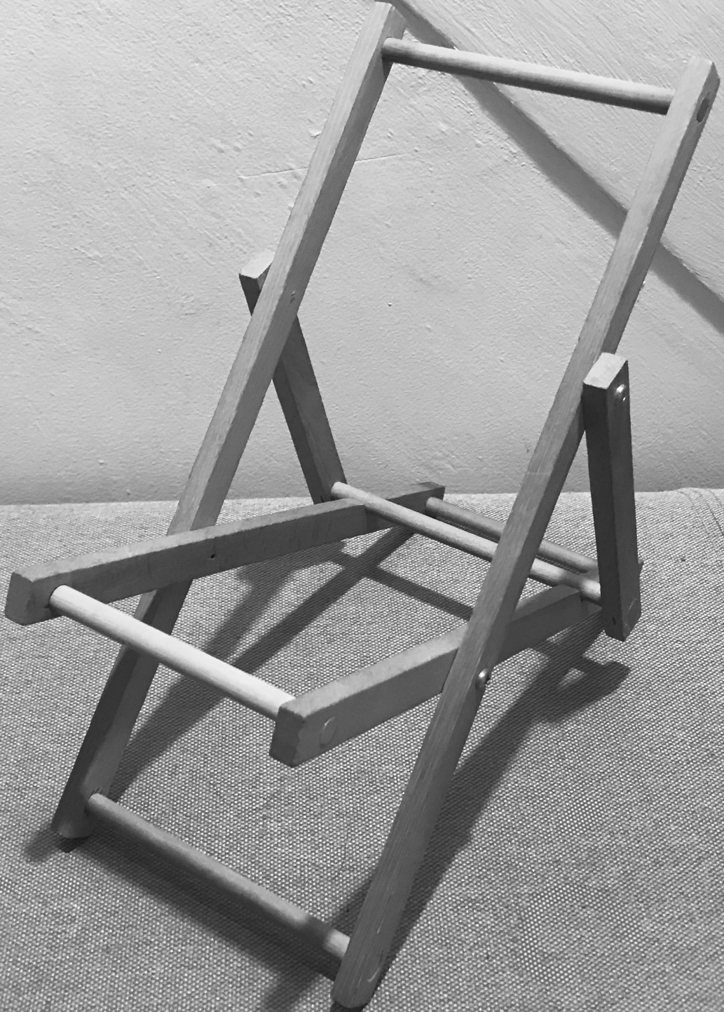 A b/w photo of a deckchair without its cloth seat.