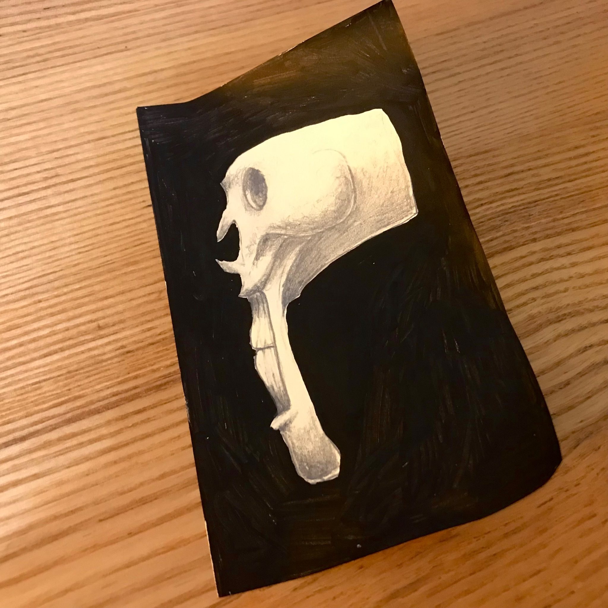 Another drawing of a distorted human skull on a post-it note.