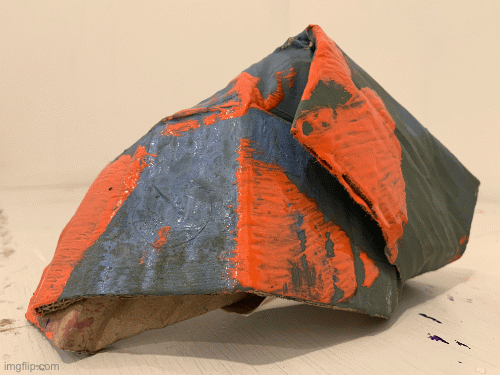small cardboard sculpture with blue and green surface and orange painted brushstrokes