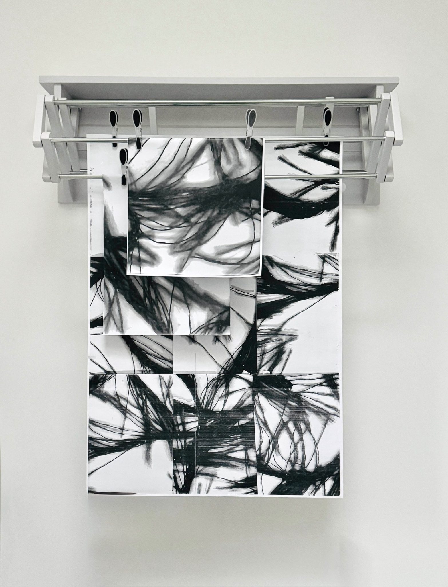 Black and white images on paper pegged to wall dryer
