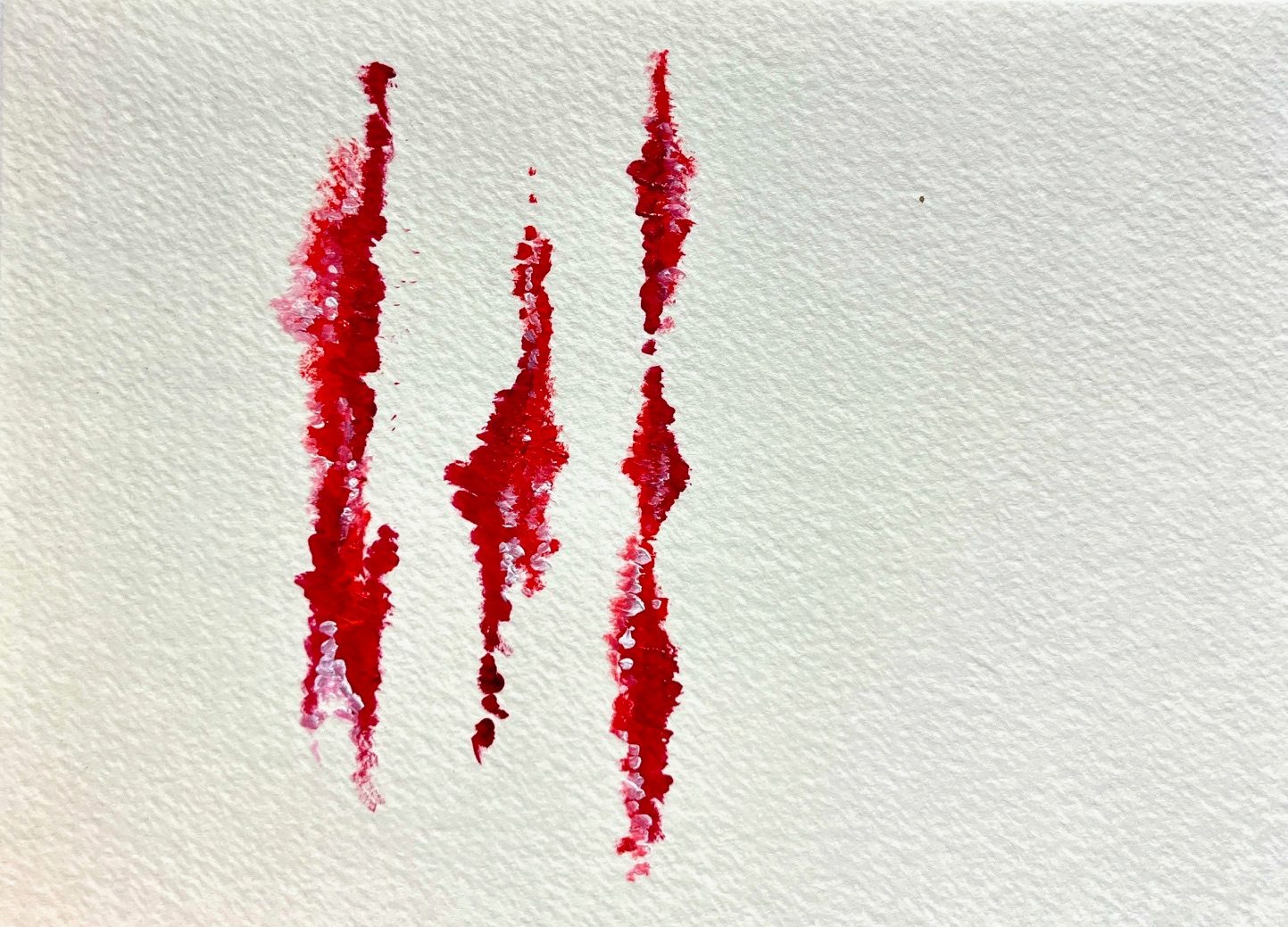 An abstract canvas using lots of negative space with red tones creating a small image