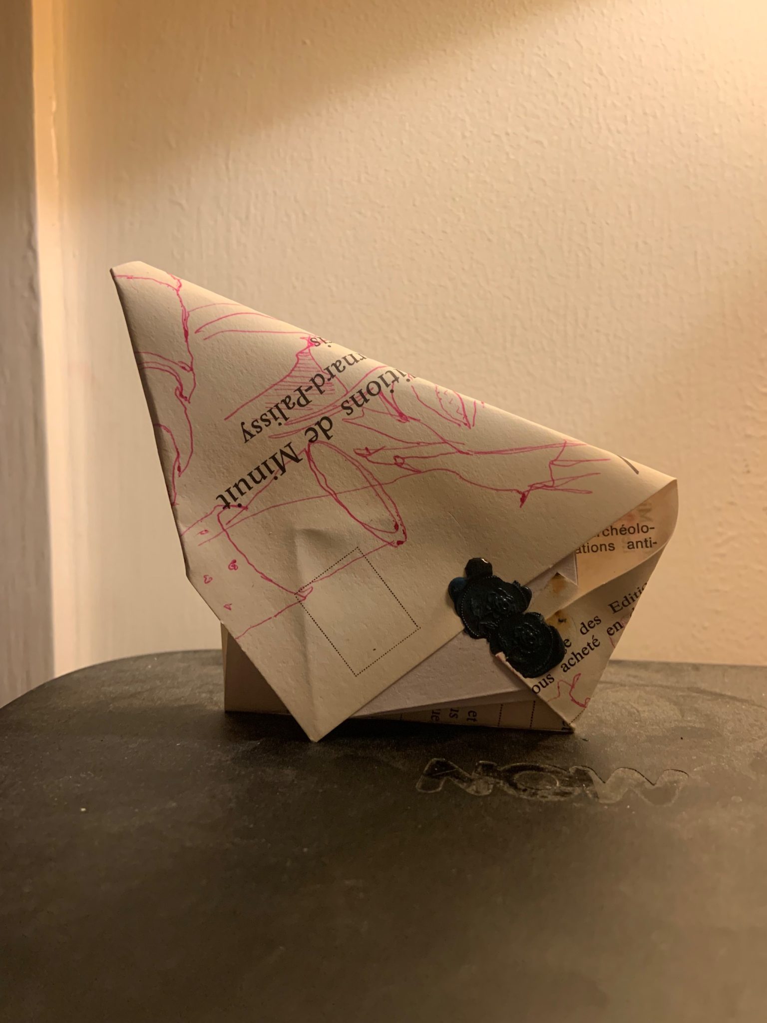 Folded postcard with French writing and pink drawing on it sealewith wax seal in green