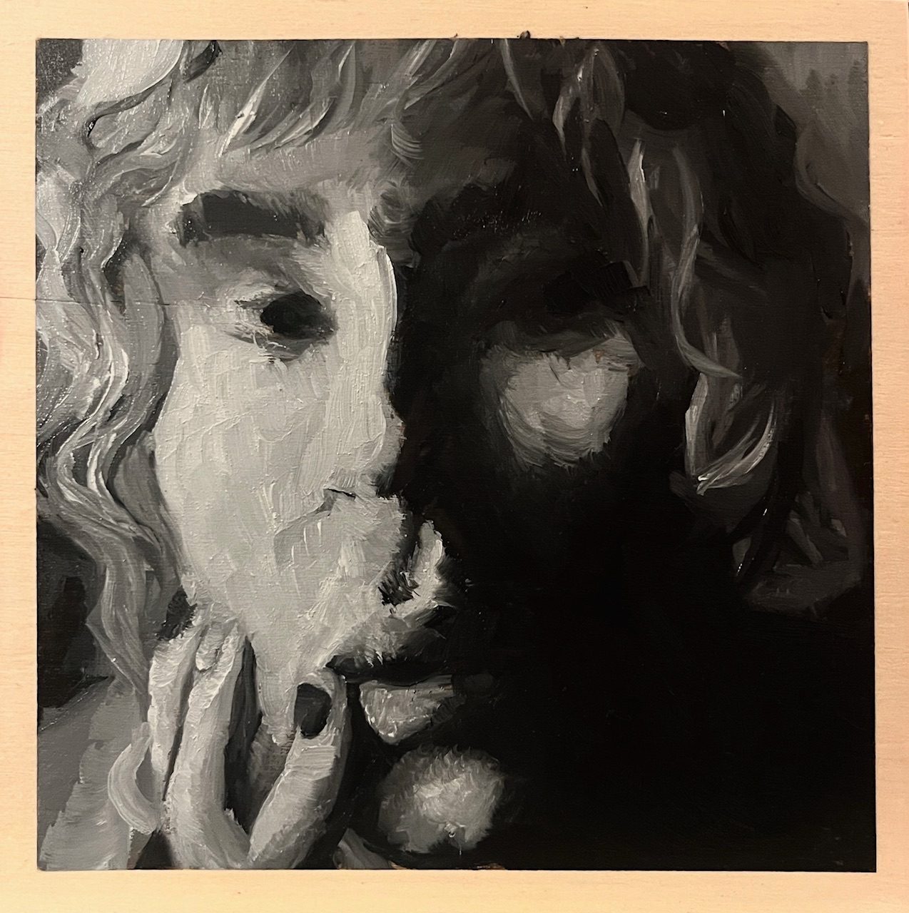 On a wood board, with a border around an oil painting. A self portrait in grey-scale tones. With a on the left cheek looking at the viewer. With a neutral expression.